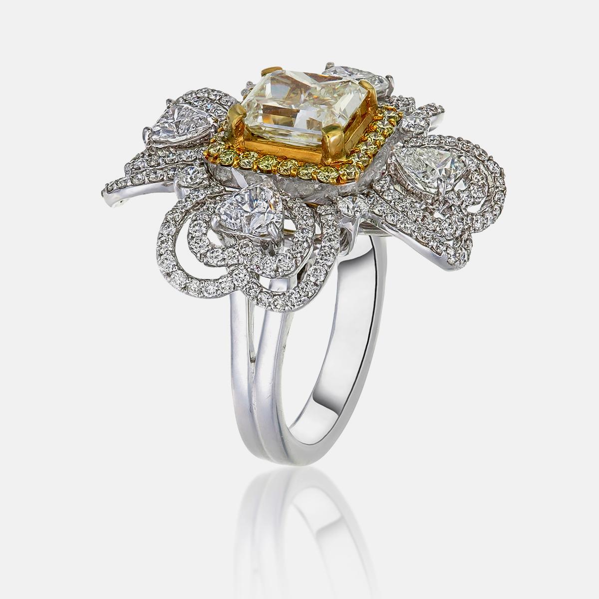 Cette bague est ornée d'un diamant jaune fantaisie de 2,42 carats de taille coussin. Quatre diamants taillés en cœur, totalisant 1,47 carat, ainsi que 0,35 carat de diamants jaunes et 1,30 carat de diamants taillés en rond, rehaussent sa beauté.