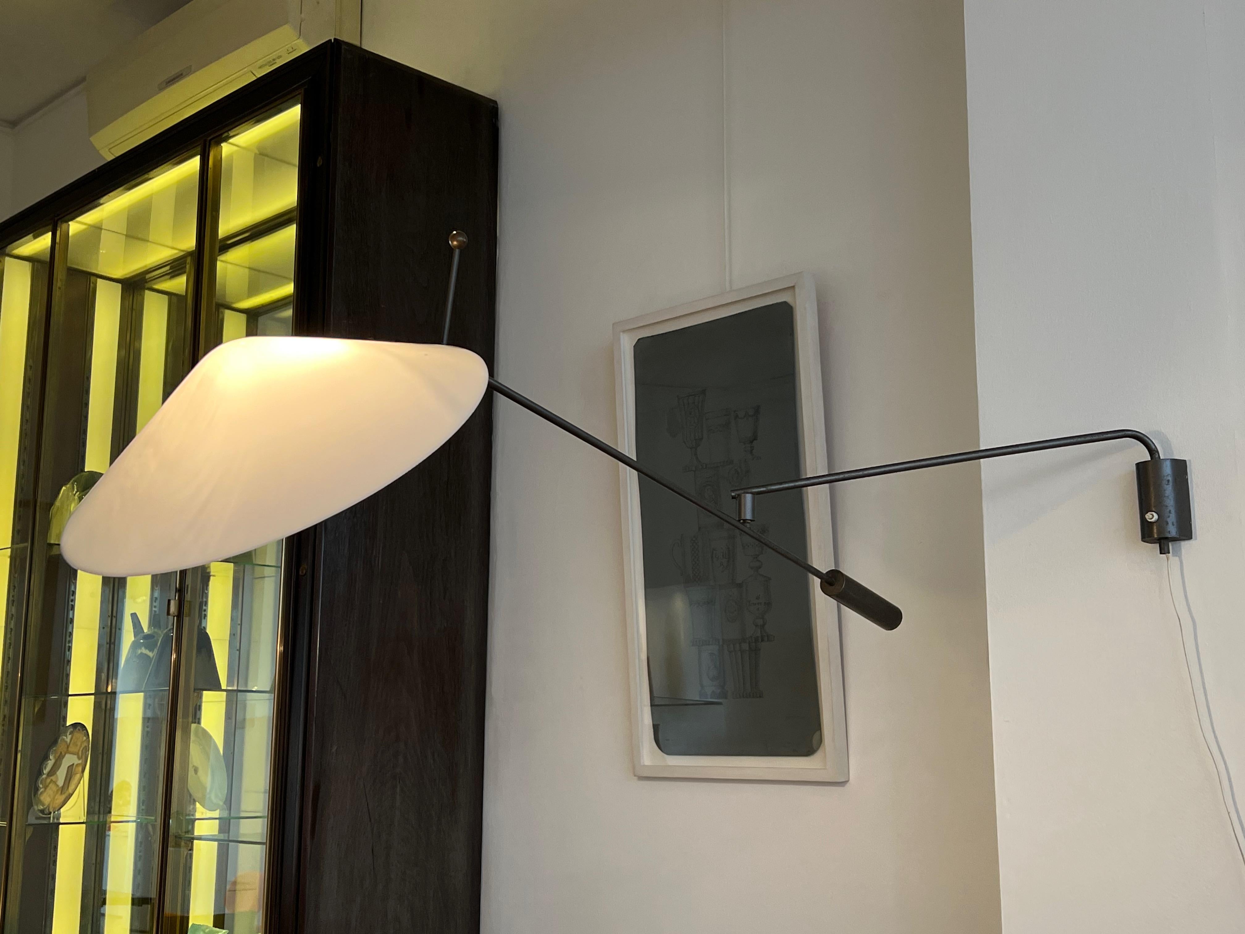 Elegant and dramatic black lacquered metal and brass wall light with perspex lampshade by renowned French post-war lighting designer, Robert Mathieu. His training at the prestigious Ecole Boulle and experience as a watchmaker inform the precision