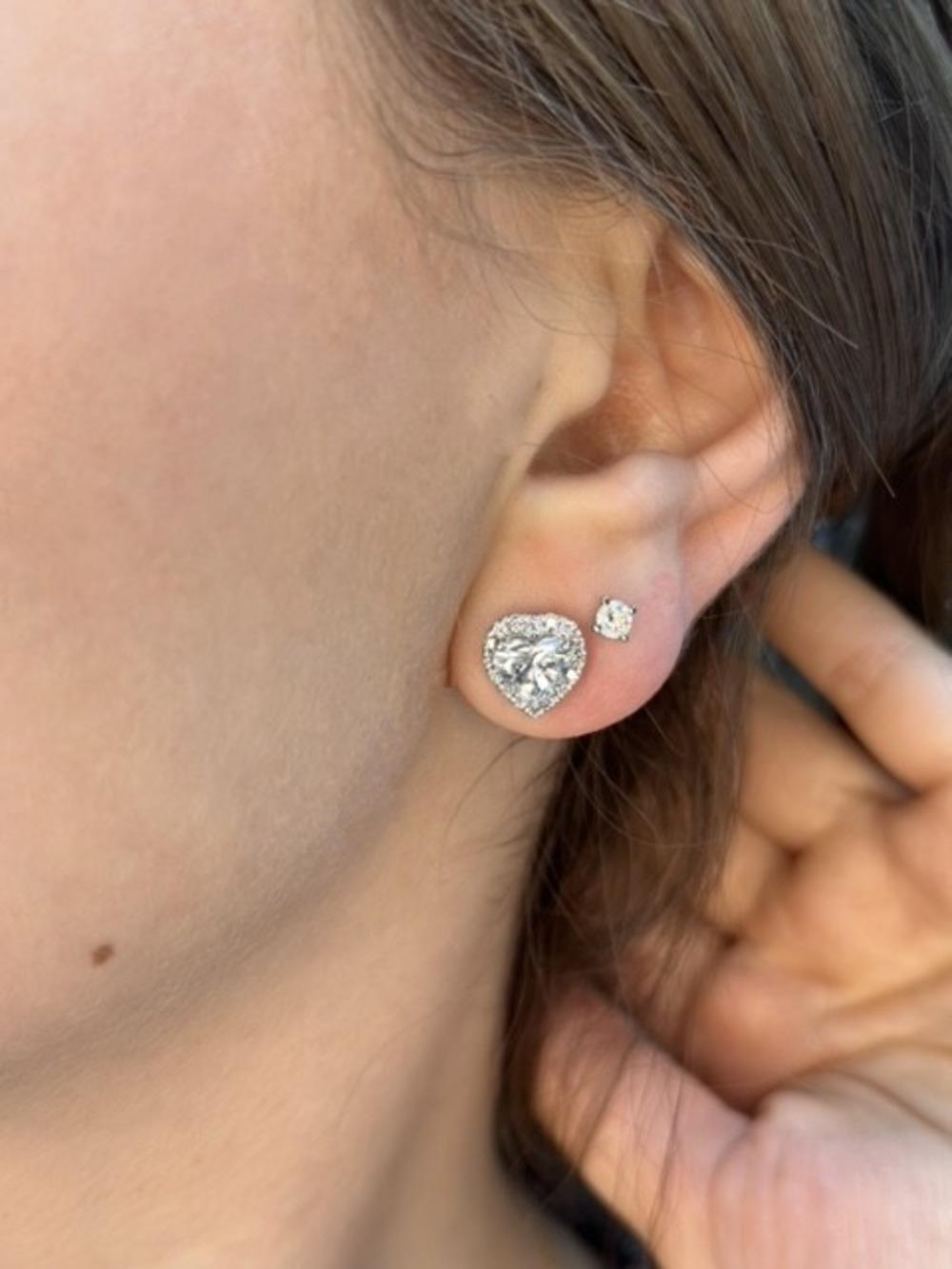 These amazing Heart Shape Diamond Halo Studs in 14K White Gold have a center stone with 1 Carat in each earring and surrounding the heart-shaped center stone is a halo of smaller diamonds that add an extra touch of luxury and brilliance. These studs