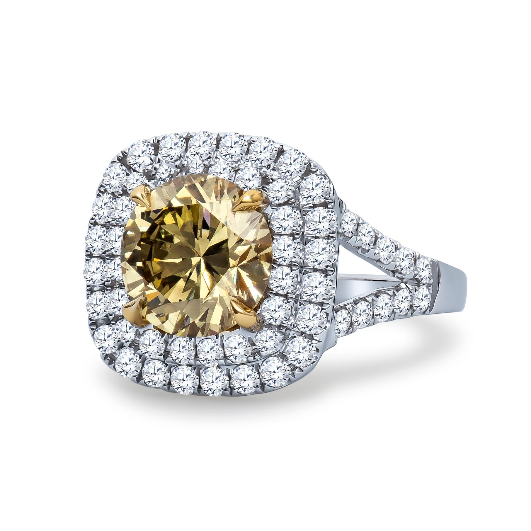 2.43 Carat, GIA certified, round brilliant cut 'natural fancy brownish greenish yellow' center diamond with a VS2 clarity. Double halo form in 0.94 carats total weight in accent diamonds set in an 18K white and yellow gold ring with filigree detail.