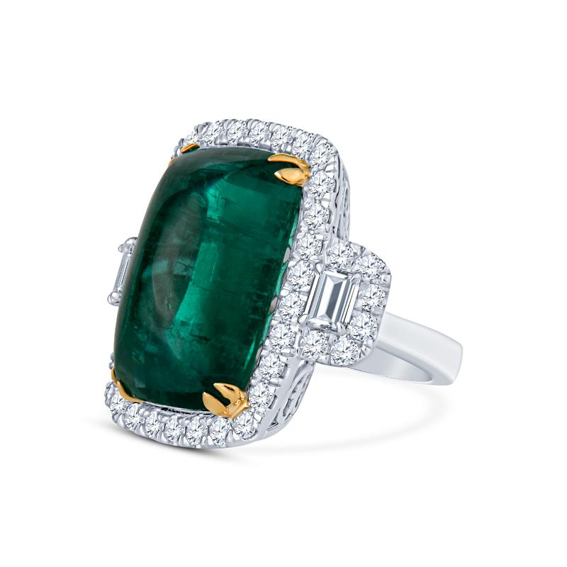 This exquisite ring showcases a breathtaking 24.32 carat cabochon emerald complemented by 2.76ct of natural diamonds in emerald and round brilliant cuts. Crafted from luxurious 18 karat white and yellow gold, it is a one-of-a-kind piece that adds