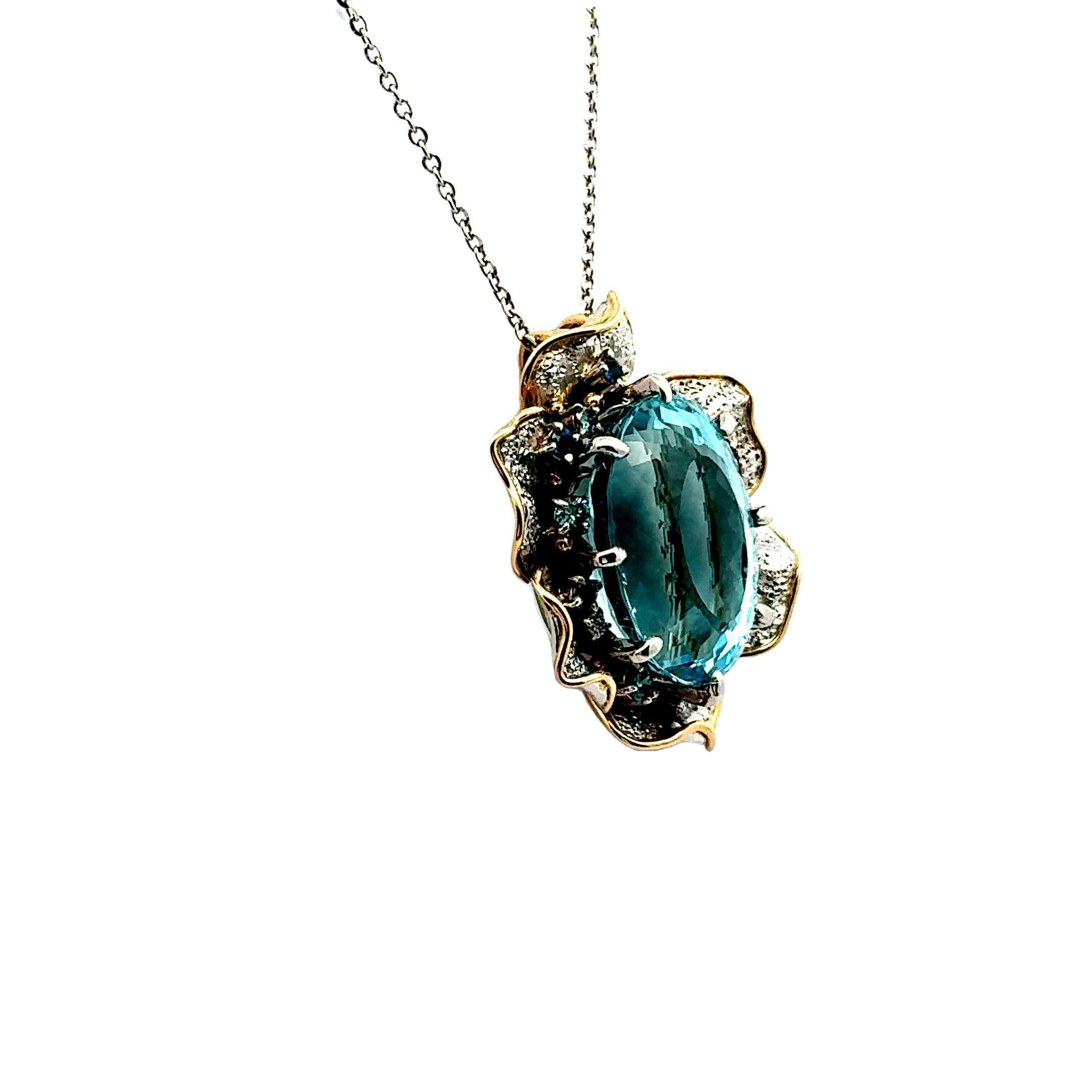 Un llamativo collar colgante con una magnífica aguamarina ovalada de 24,34 quilates. La aguamarina muestra un cautivador y vibrante tono azul marino, engastada en un diseño floral. Está acentuado con 0,42 quilates de zafiros azules redondos, que
