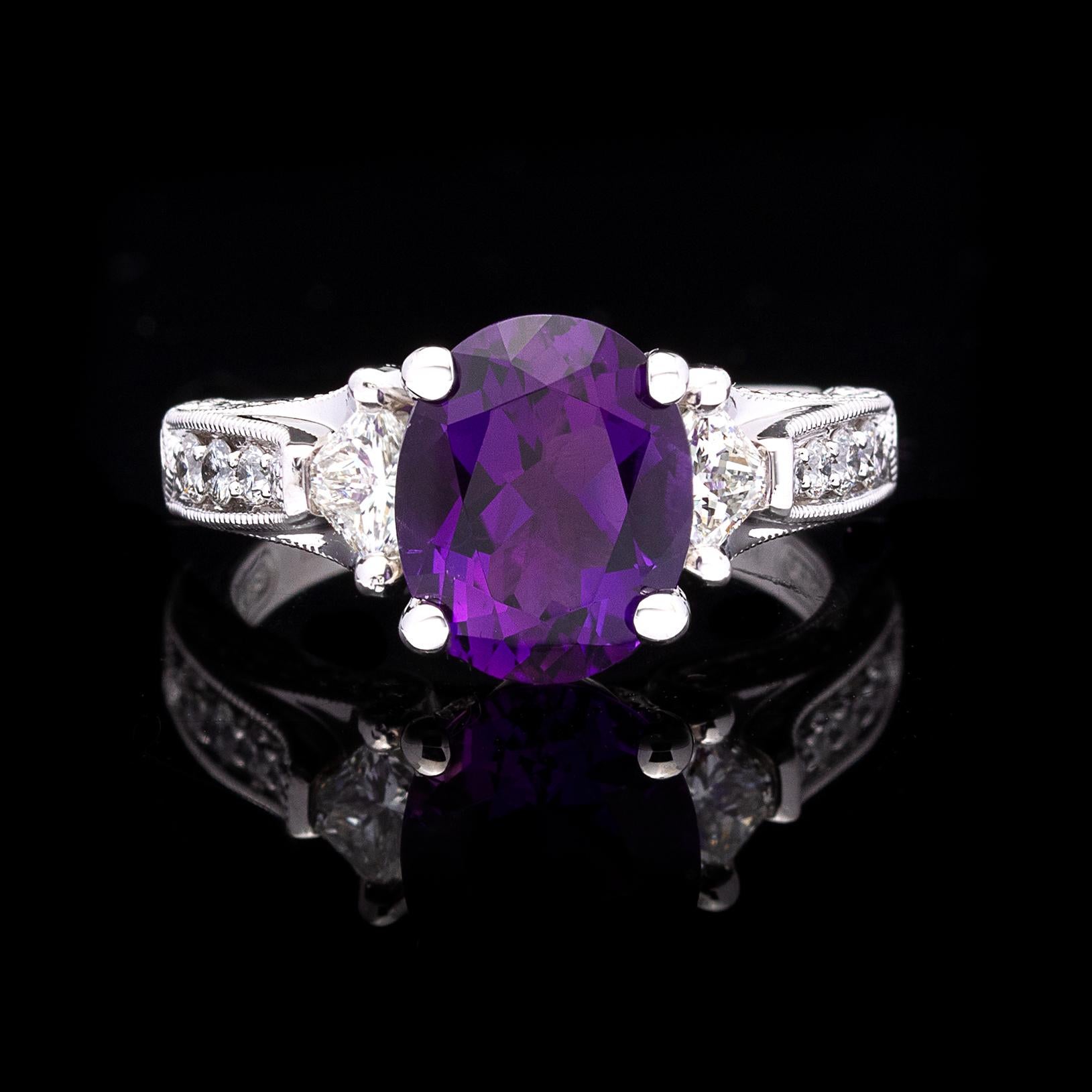 Deep lustrous purple is the color of Royalty. This platinum ring features a 2.43-carats oval-cut purple amethyst with subtle hints of pink, accented with two princess and 32 round brilliant-cut diamonds for a total of 0.73-carat. The ring weighs 9.5