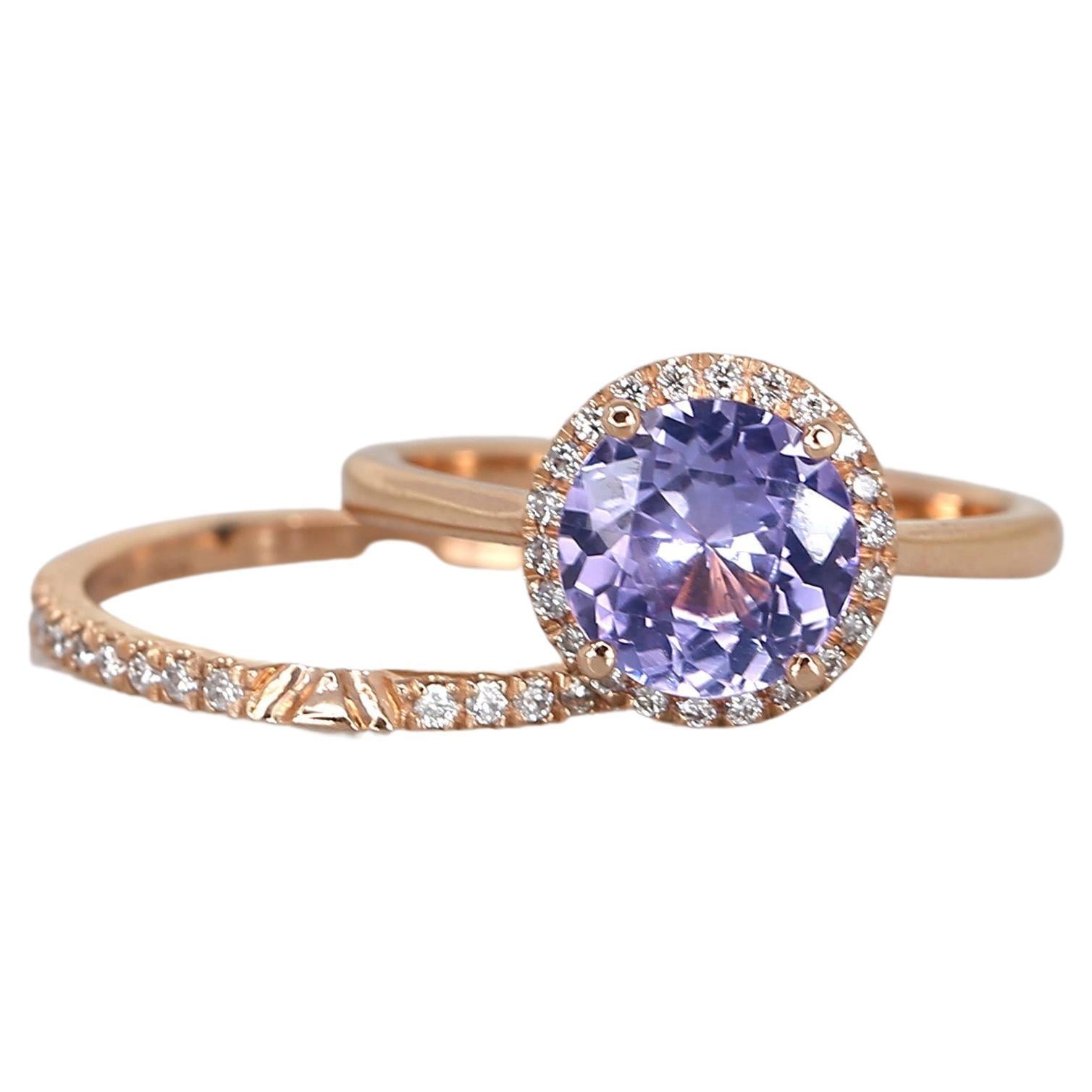 Discover our exquisite our purple sapphire halo ring and matching diamond wedding ring. This stunning set showcases a unique purple sapphire in a timeless round halo design. The dainty yet elegant style of the halo ring perfectly complements the