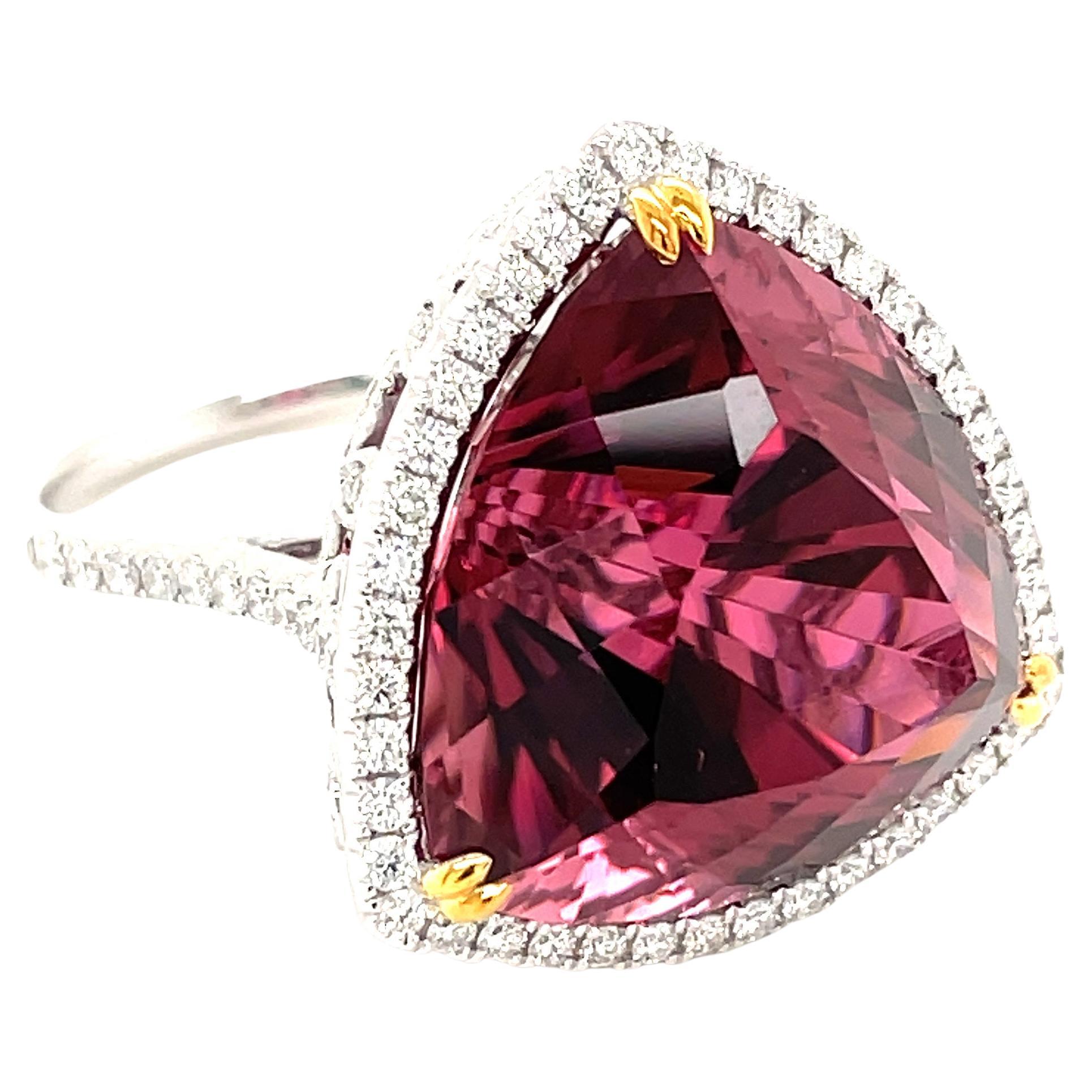 This stunning cocktail ring showcases a beautiful 24.42 Carat Trillion Cut Rubellite Tourmaline with a Diamond Halo on a Diamond Shank. This ring is set in 18k white gold, with 18k yellow gold prongs on the center stone.
Total Diamond Weight = 0.76