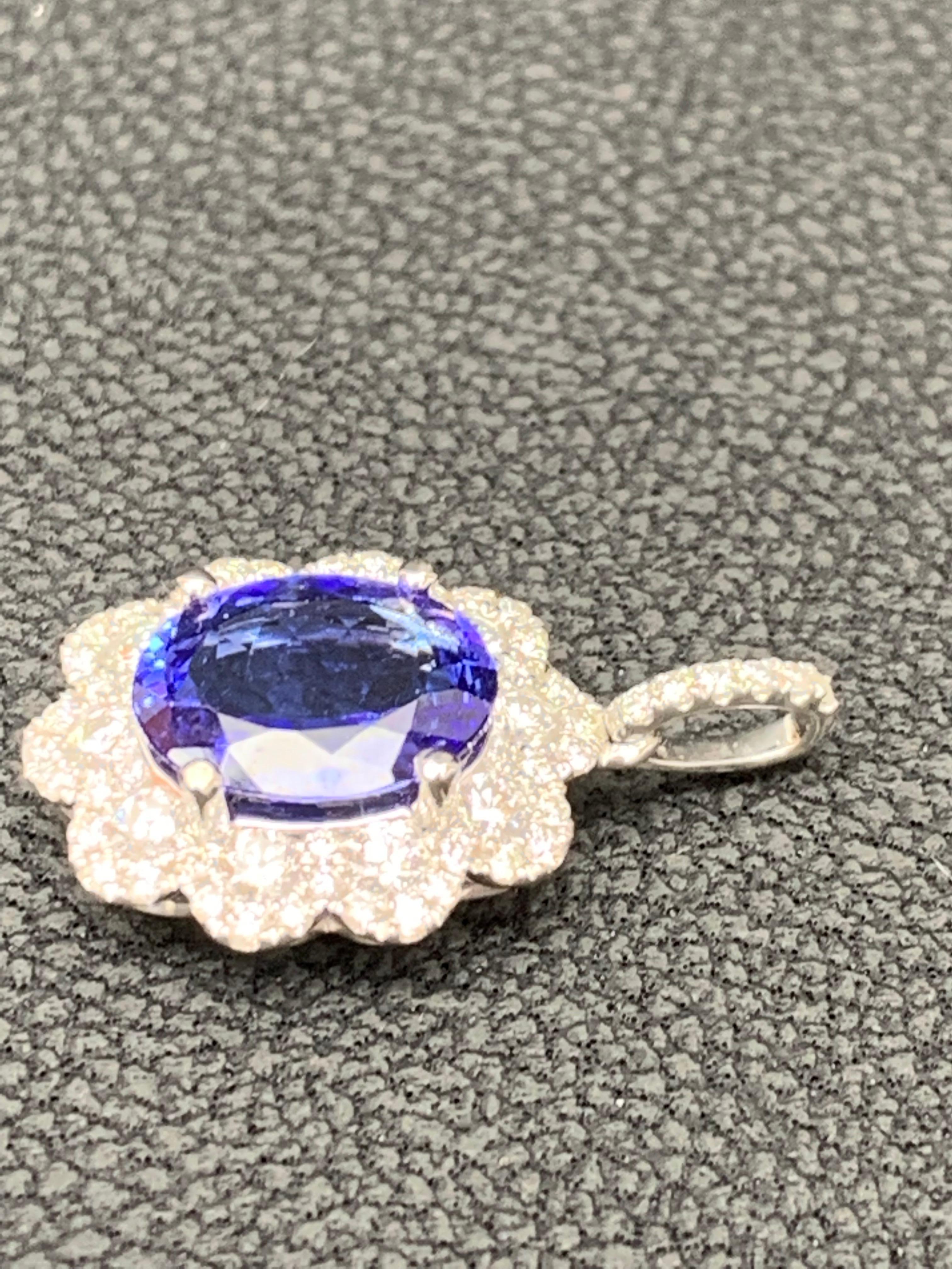 A simple floral motif pendant necklace showcasing a vibrant 2.45-carat oval cut tanzanite, surrounded by 0.74 carats of 62 accent round diamonds. Made in 18 karats white gold.

Style available in different price ranges. Prices are based on your