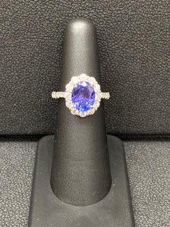 2.45 Carat Oval Cut Tanzanite and Diamond Halo Flower Ring in 18K White Gold