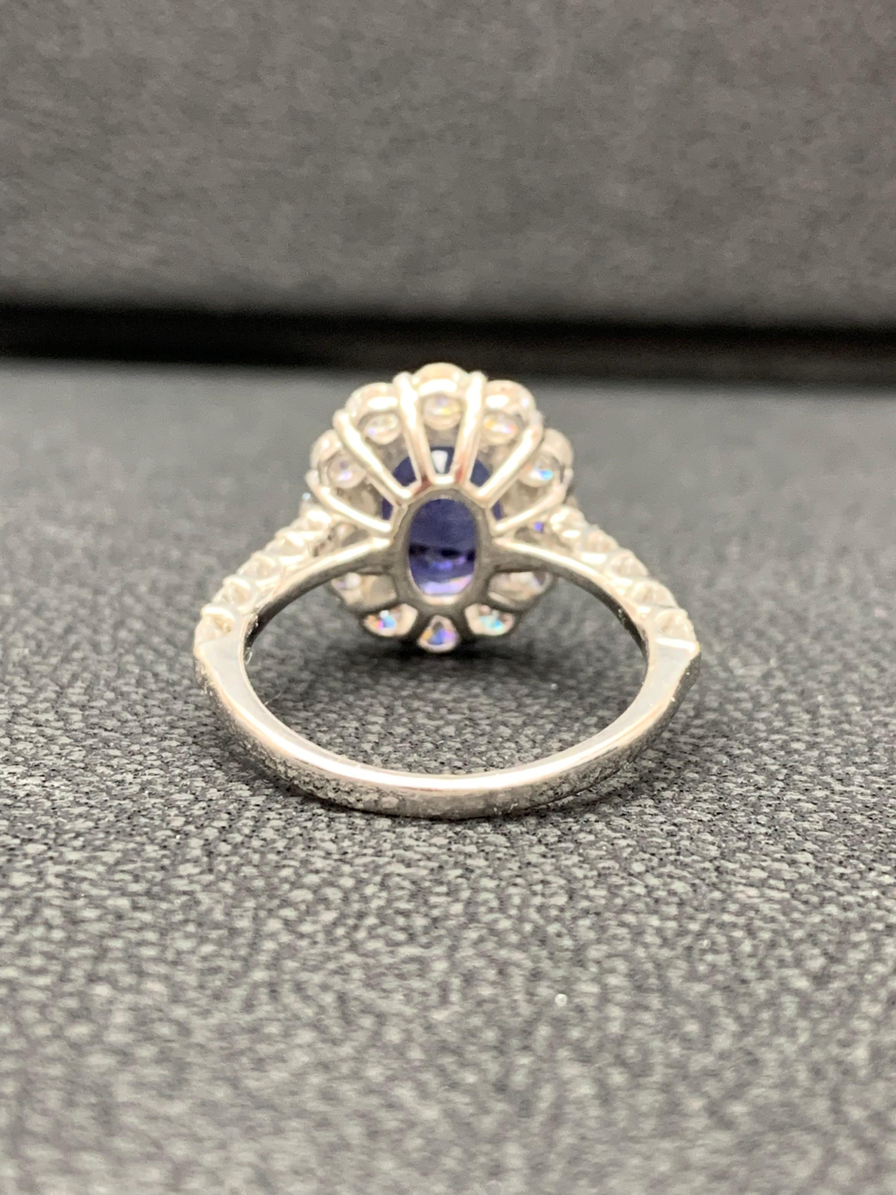 Modern 2.45 Carat Oval Cut Tanzanite and Diamond Halo Flower Ring in 18K White Gold For Sale