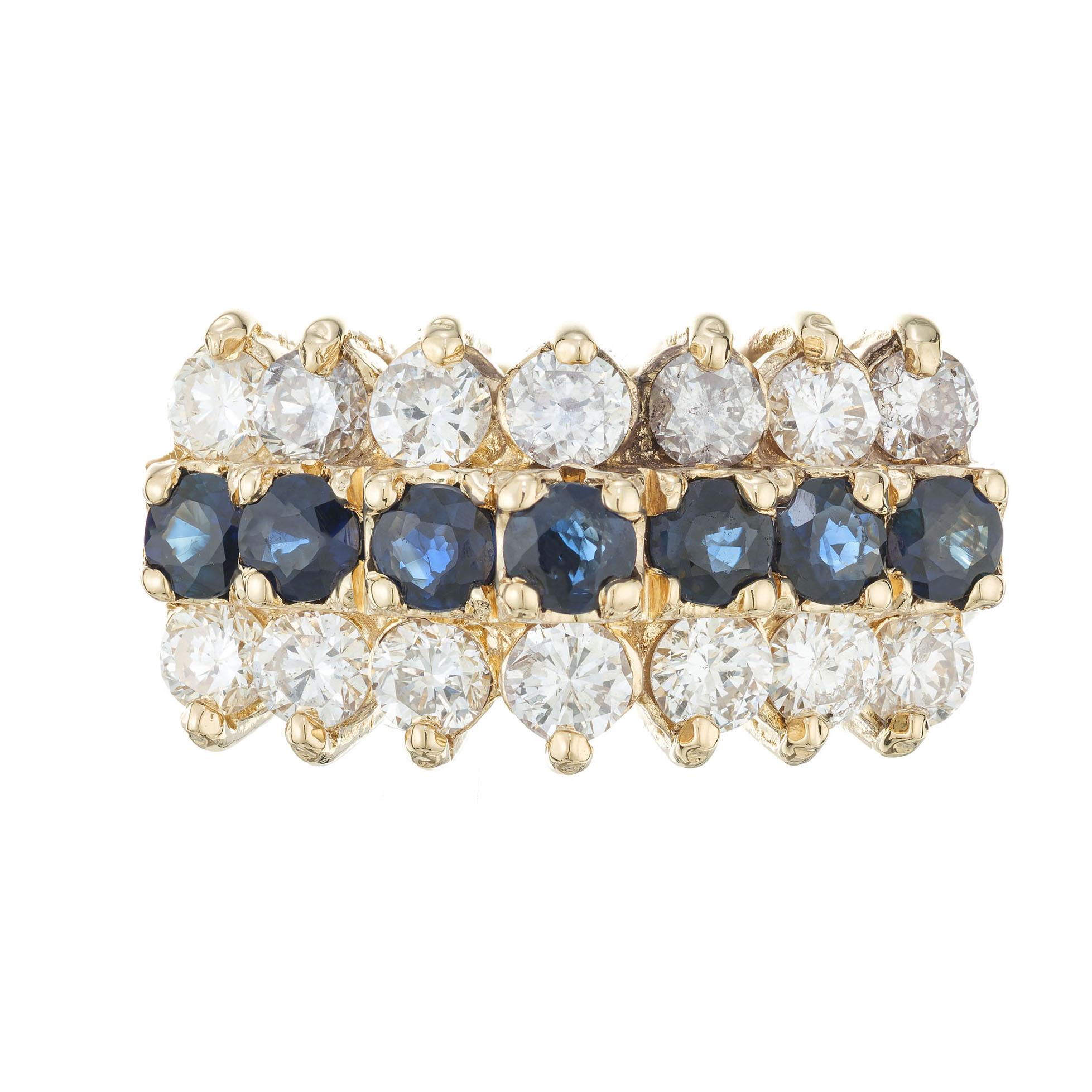 Sapphire and diamond raised crown cluster cocktail ring. Two rows of  white round diamonds along a center row of deep blue sapphires in 14k yellow gold setting. 

14 round diamonds approx. total weight 1.40cts, G, SI1
7 round sapphires approx. total