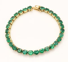 Bracciale con gemma ovale di smeraldo verde da 24,5 carati intarsiata in oro giallo 14 carati