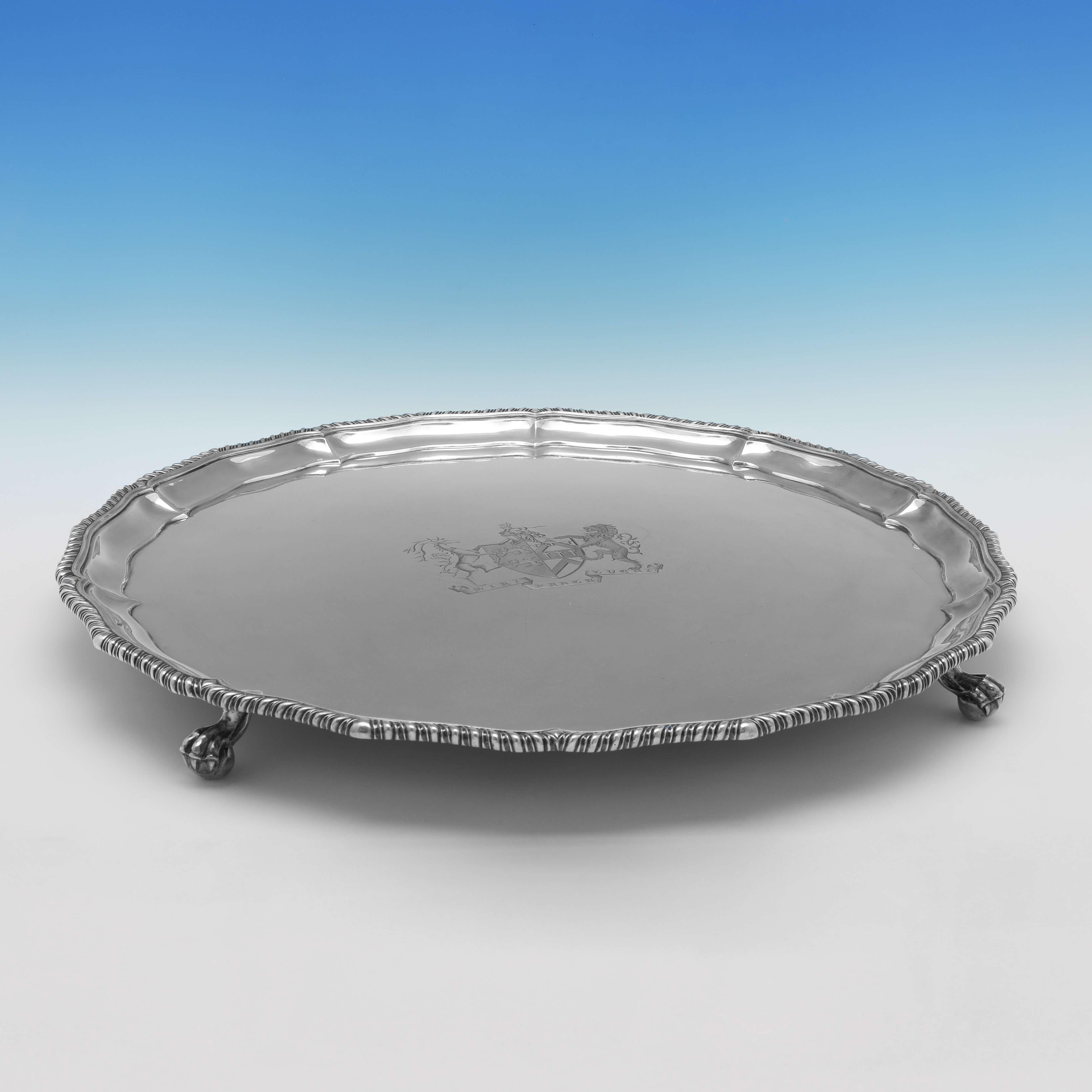 Hallmarked in London in 1874 by Edward Kerr Reid, this incredible, Victorian, Antique Sterling Silver Salver, stands on four feet, and features a gadroon border and an engraved coat of arms to the centre. The salver measures 2.25