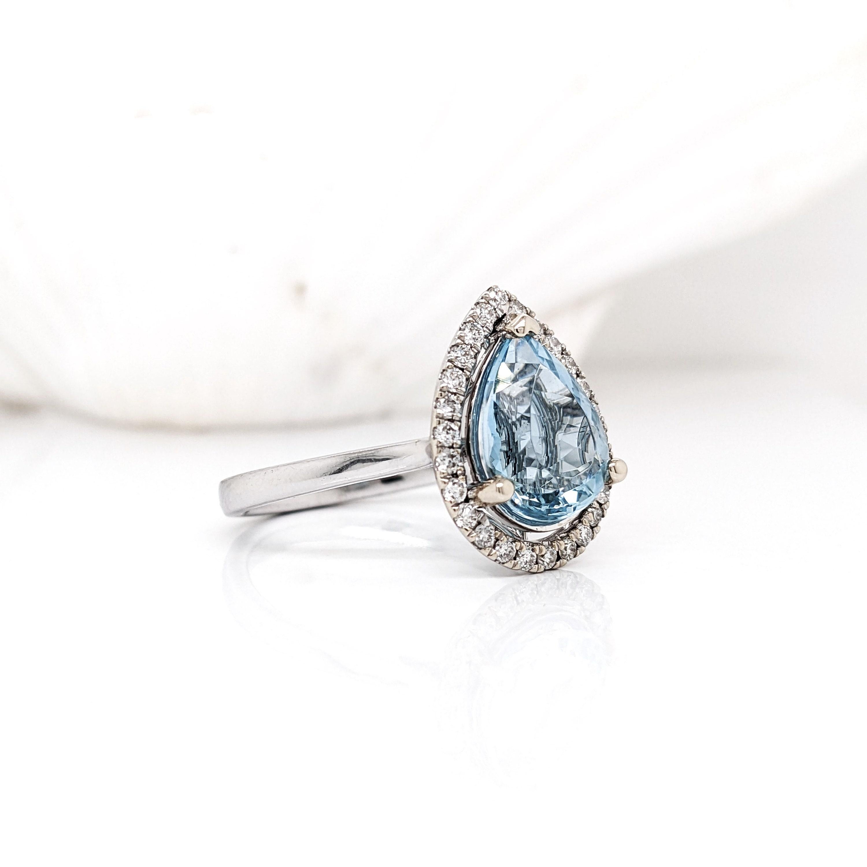 This beautiful ring features a teardrop sparkling Aquamarine in 14k white gold with a lovely halo of round natural diamonds. A statement ring design perfect for an eye catching engagement or anniversary. This ring also makes a beautiful birthstone