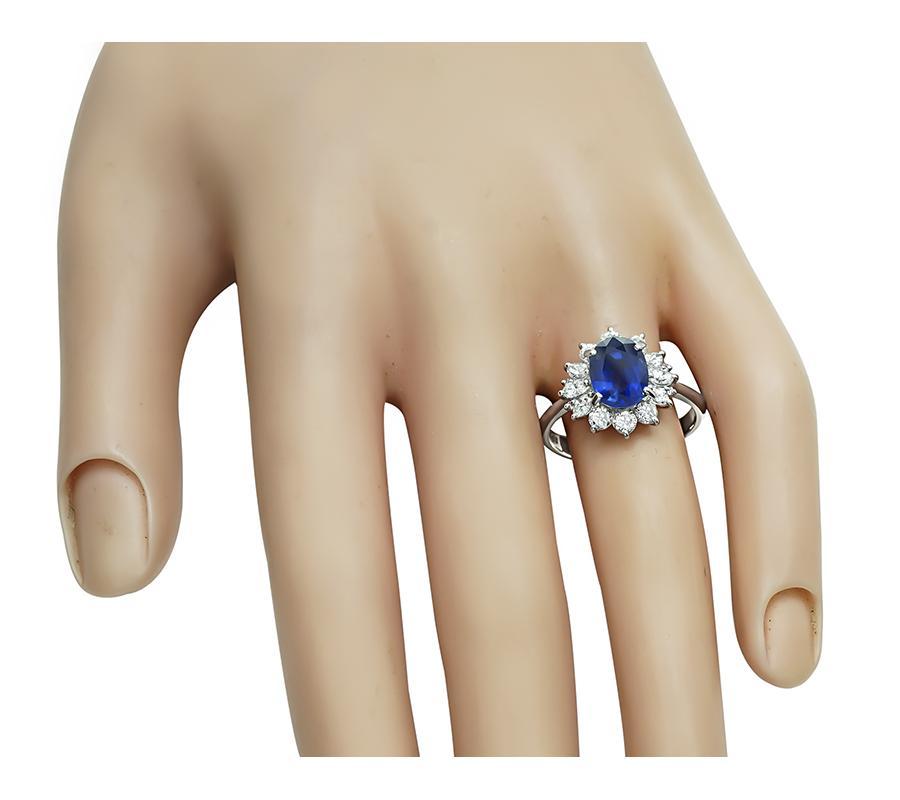 This is charming platinum engagement ring. The ring is centered with a lovely oval cut sapphire that weighs approximately 2.45ct. The sapphire is accentuated by sparkling round and marquise cut diamonds that weigh approximately 0.80ct. The color of