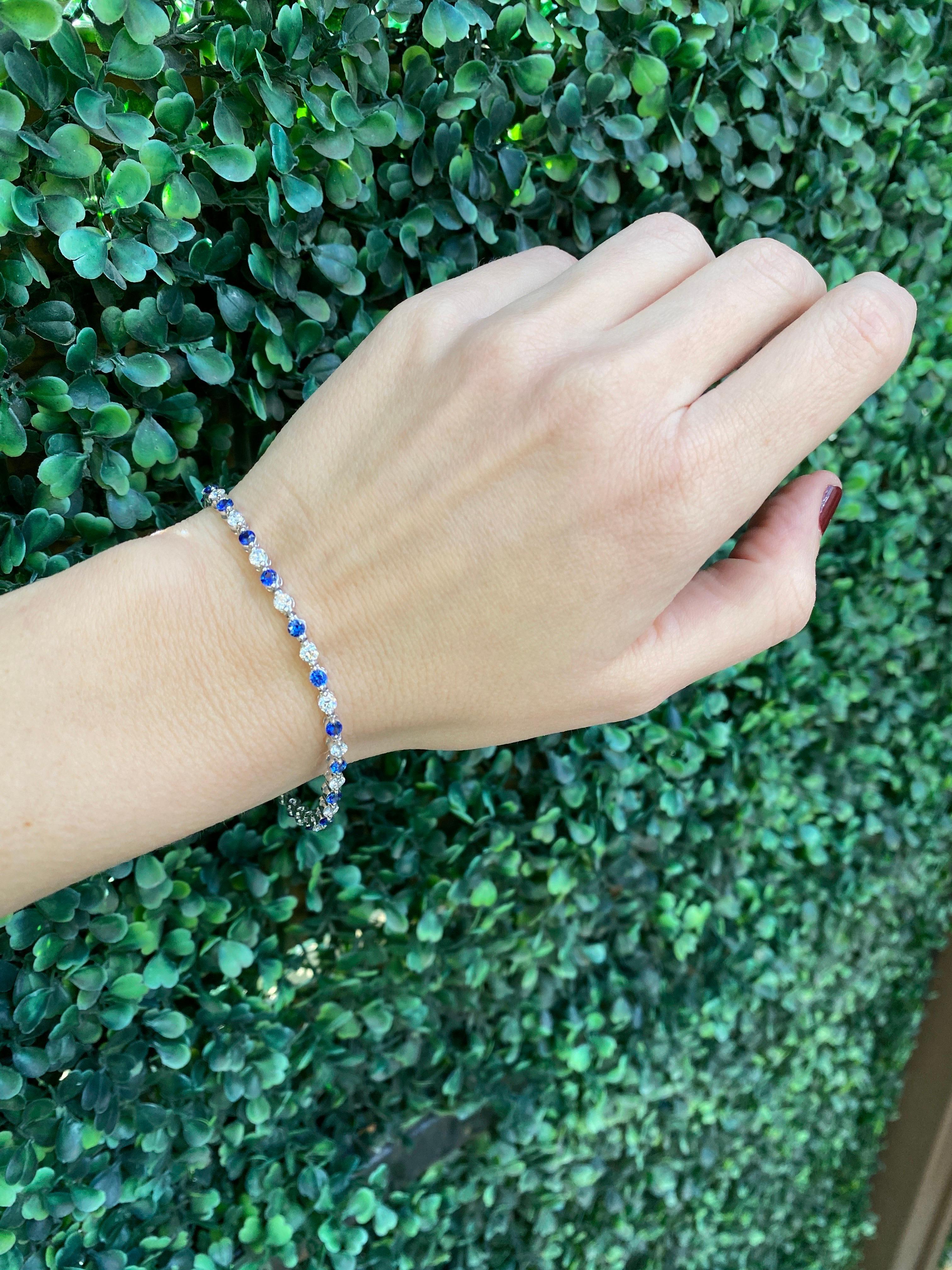 This beautiful bracelet features 2.45 carat total weight in round natural blue sapphires alternating with 2.01 carat total weight in round natural diamonds set in 14 karat white gold. It has a box clasp with safety closure. Wear alone of layer with