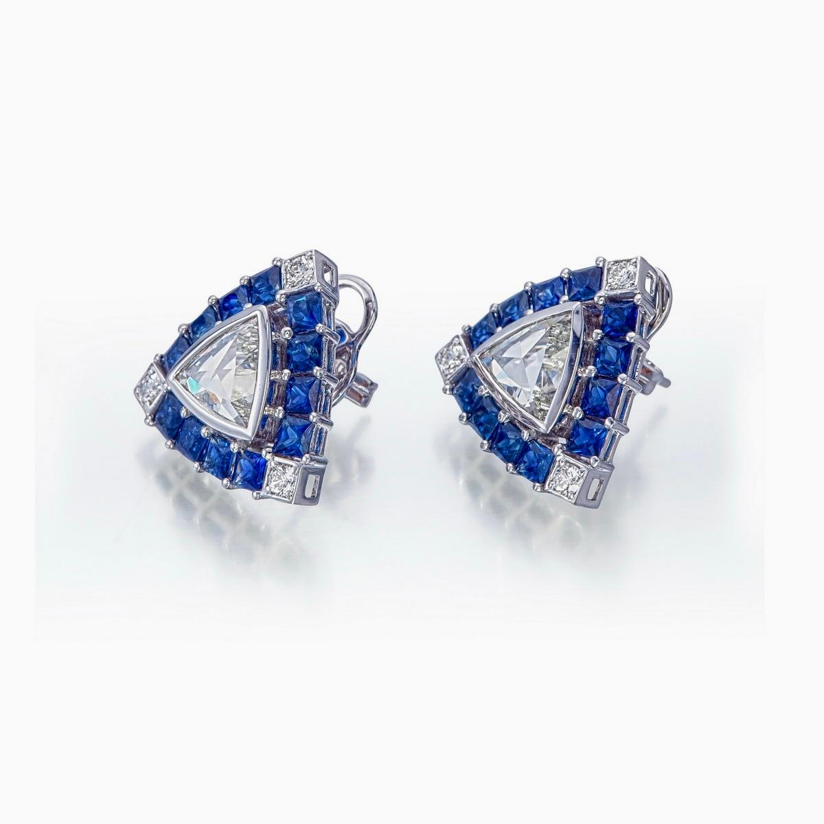 Un par de modernos pendientes vintage de diamantes y zafiros azules de Rewa Jewels, inspirados en temas art déco.
- Dos trillones de diamantes de talla fantasía centrales con un peso aproximado de 2,46 quilates.
- Seis diamantes redondos de apoyo.