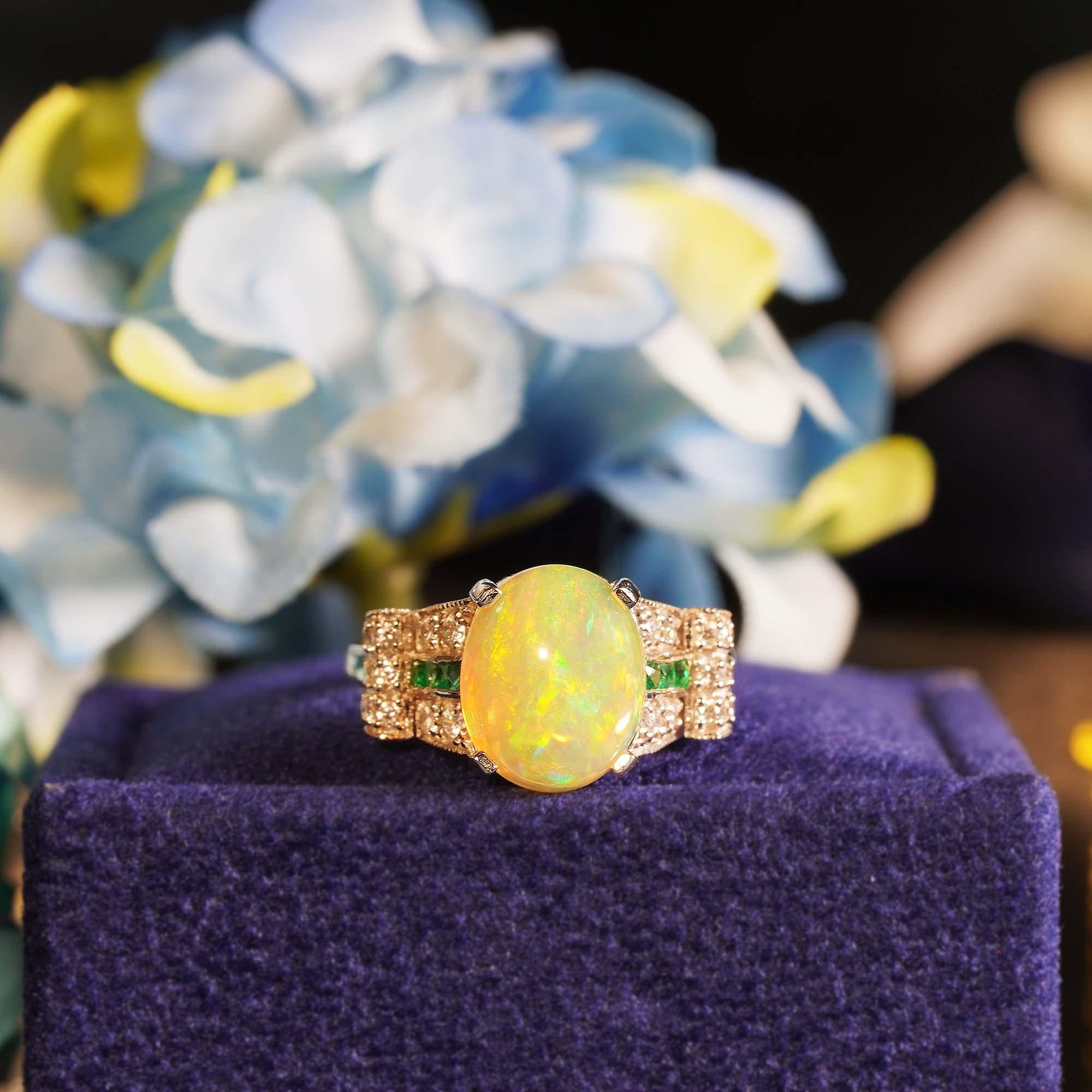 A well balanced Art Deco inspired ring that has a central 2.46 carats play-of-color Ethiopian opal with French cut emerald and shimmering diamonds on either side. This gorgeous ring would make a perfect engagement ring.

Ring Information
Style: