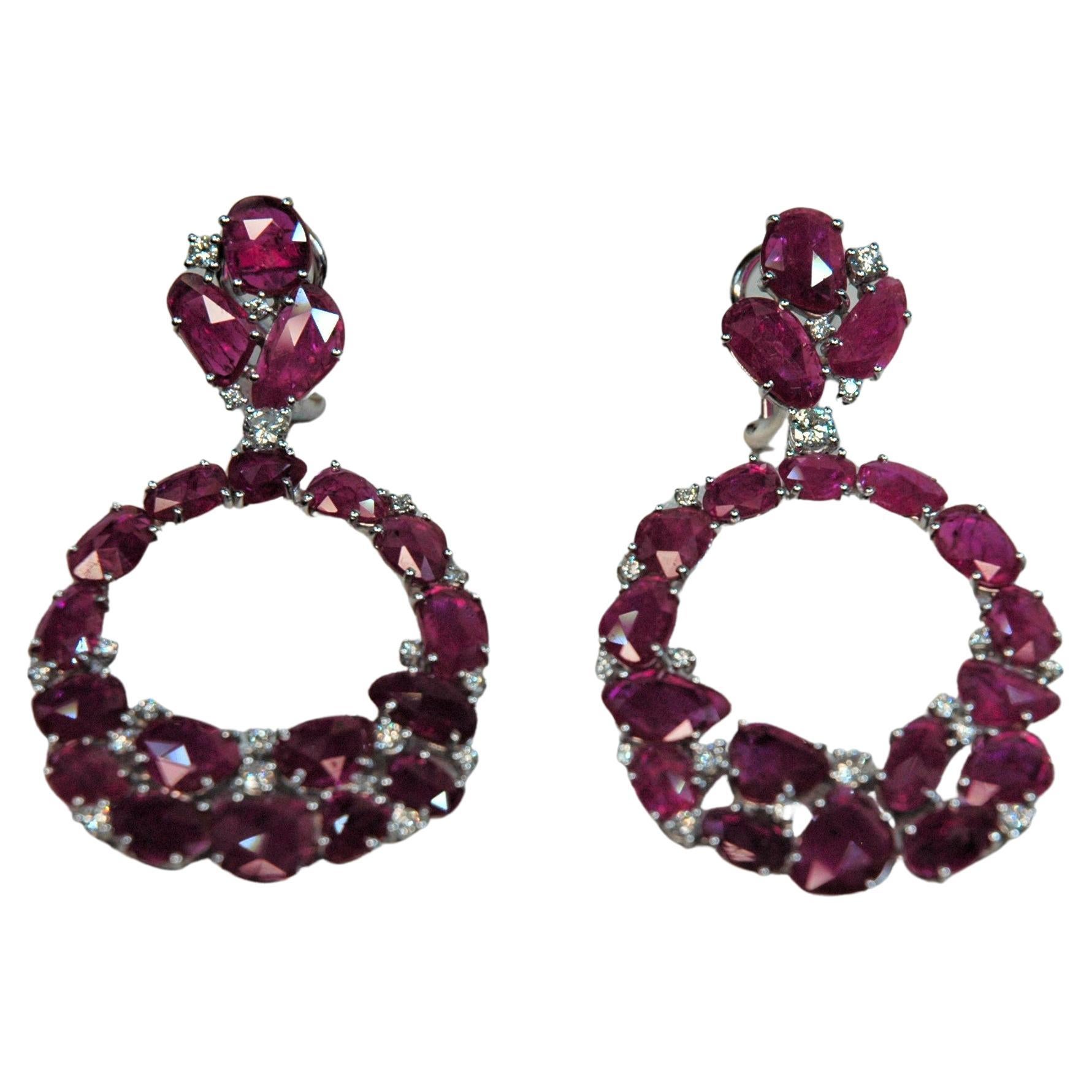 Estos pendientes tan de moda están hechos a mano en Italia. Las piedras de rubí son planas y todas diferentes entre sí. Se juntan con diamantes para crear una forma ovalada perfecta que cuelga de la parte superior de los pendientes. Puedes llevar