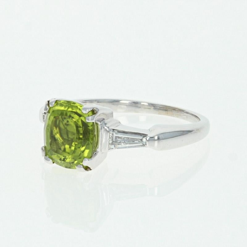 Vivacious color and sweet shine unite in this exquisite gemstone ring! Composed of glistening 14k white gold, this ring showcases a mesmerizing peridot solitaire beautifully accompanied by two shimmering white diamond accents which adorn the ring’s