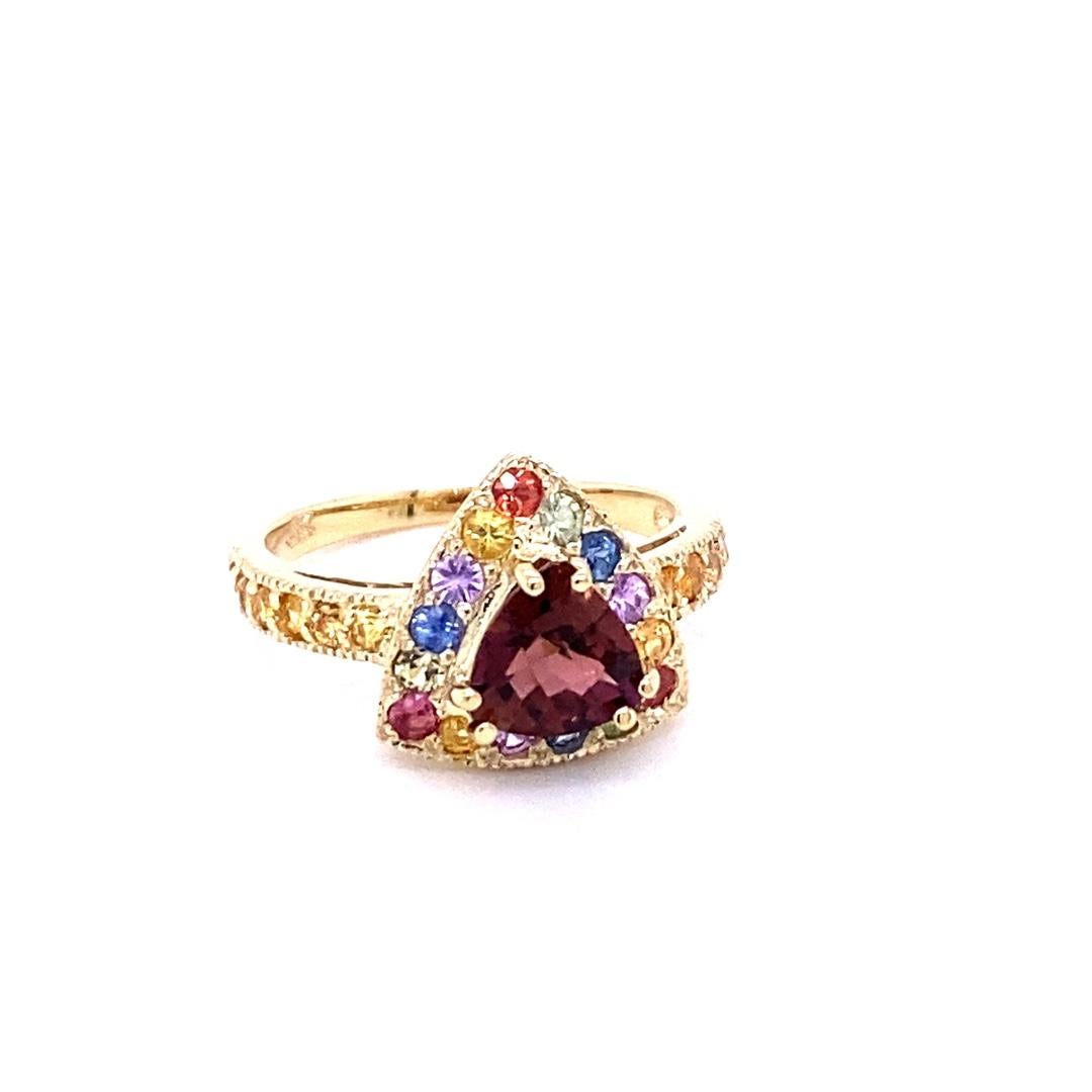 This ring has a Trillion Cut Tourmaline that weighs 1.14 carats and is surrounded by 27 Multi Sapphires that weigh 1.33 carats. The total carat weight of this ring is 2.47 carats. 

This ring is casted in 14K Yellow Gold and weighs approximately 4.2