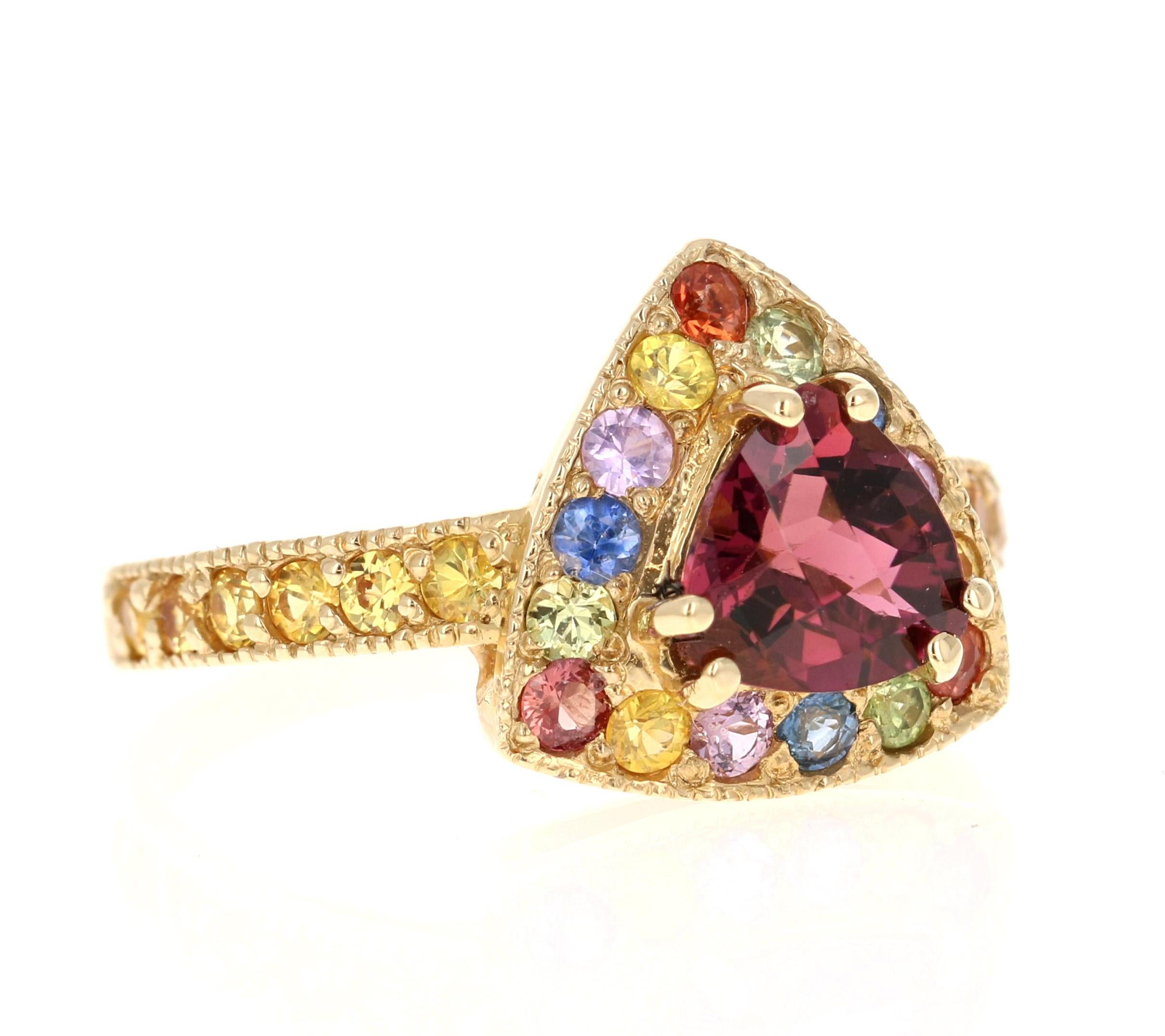 This ring has a Trillion Cut Tourmaline that weighs 1.14 carats and is surrounded by 27 Multi Sapphires that weigh 1.33 carats. The total carat weight of this ring is 2.47 carats. 

This ring is casted in 14K Yellow Gold and weighs approximately 4.2