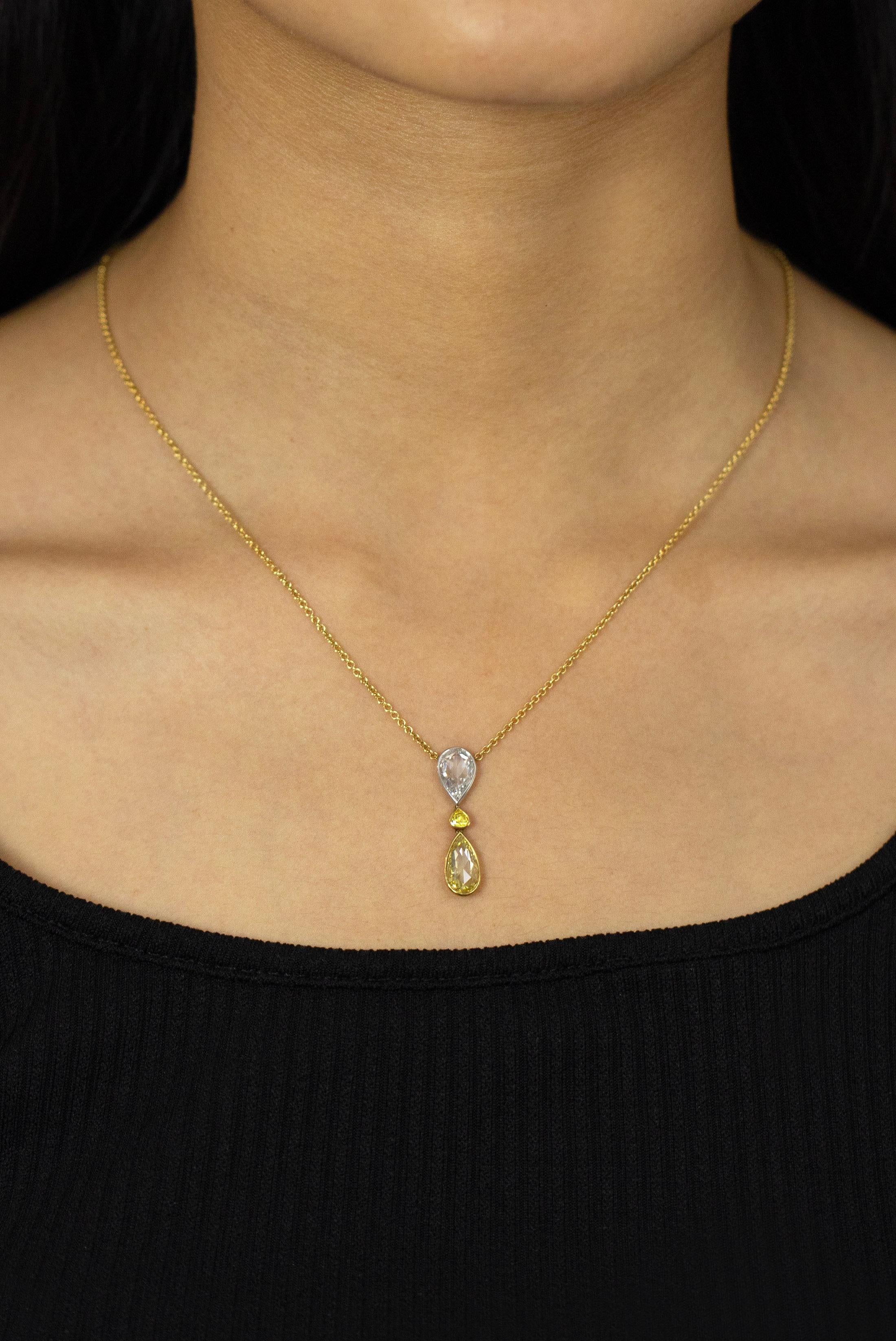 This color-rich and beautiful pendant necklace showcases a 1.18 carats pear shape diamond certified by GIA as fancy intense yellow diamond and VVS2 in clarity, bazel set in 18k yellow gold. Suspended on an inverted 1.15 carats pear shape diamond