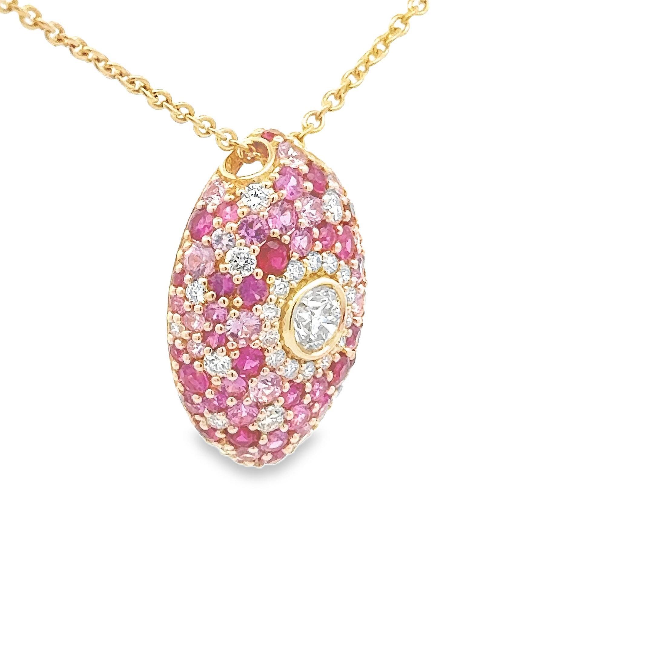 Magnifique collier pendentif de forme marquise, orné de 30 diamants ronds de taille brillant pesant 0,65 carat au total, le plus gros diamant étant serti en chaton au centre. Accentué par des rubis et des saphirs roses de taille ronde pesant 1,82