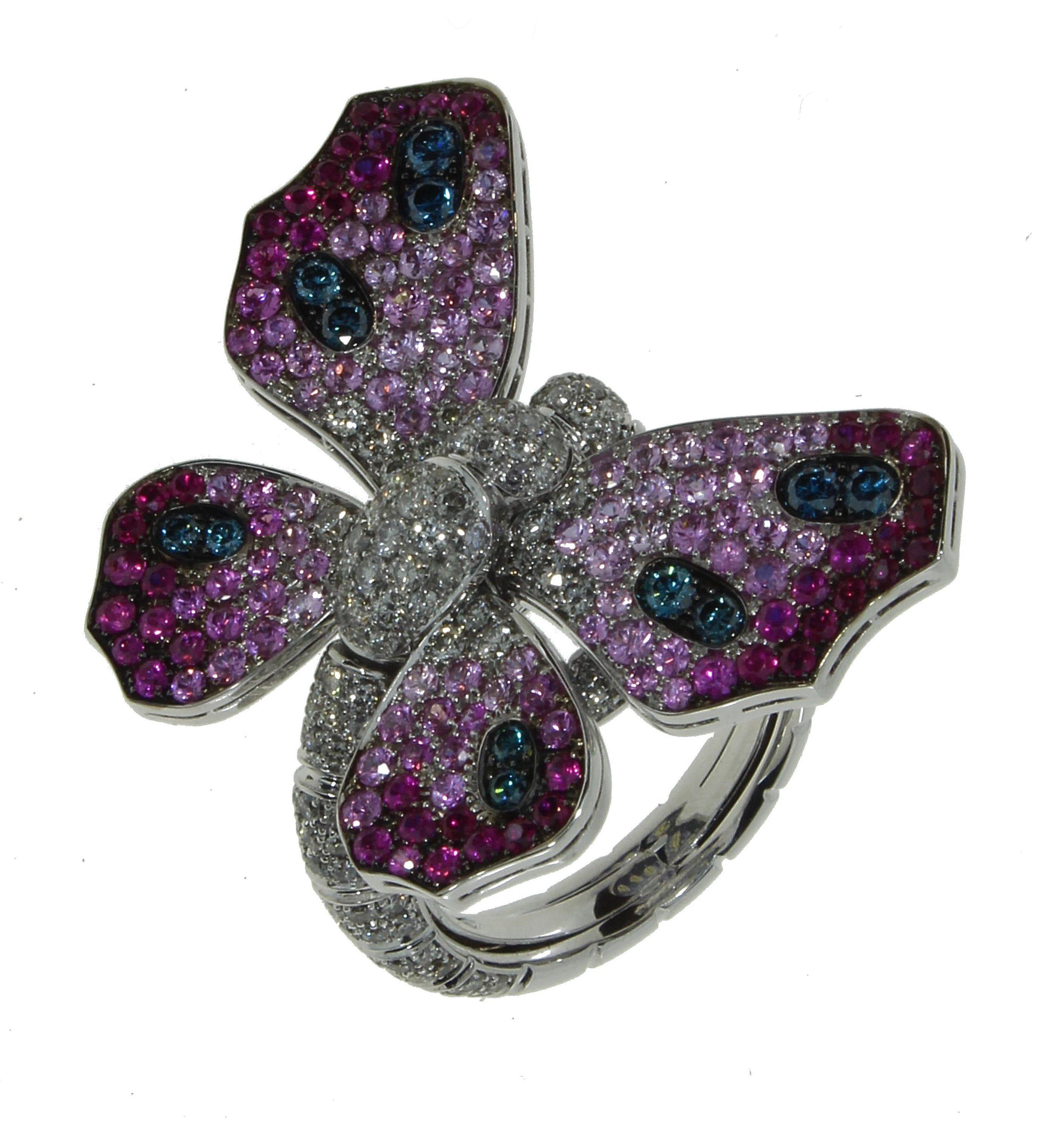 Majestic and glamorous, this 18 Kt white gold ring features a beautiful, eye-catching butterfly. One side of the butterfly is lined with white diamonds as well as light blue, dark blue and yellow sapphires. The other side has white diamonds, light