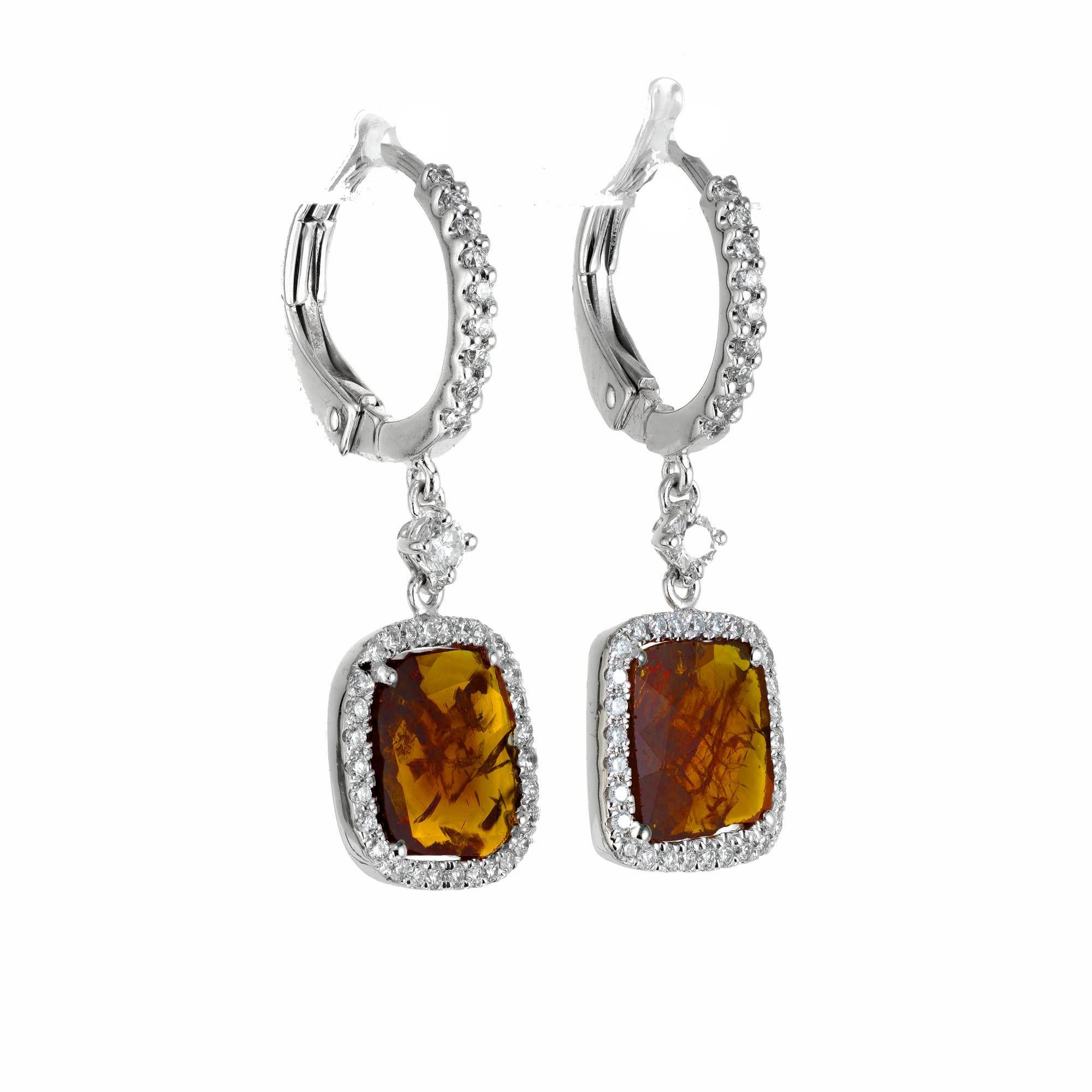 Natural citrine and diamond dangle earrings. 2 brown, yellow and orange cushion cut citrines with a halo of 78 round diamonds. 14k white gold lever back settings. 

2 orange yellow natural Citrine approx. total weight 2.48cts, natural inclusions
78