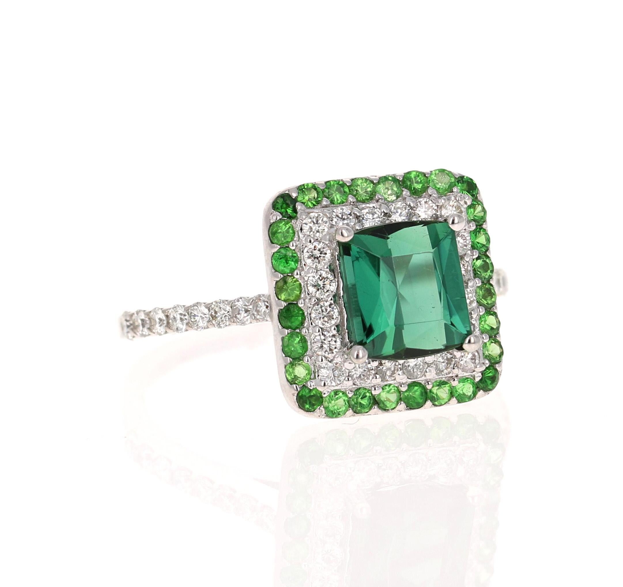 Dieser Ring hat einen wunderschönen grünen Turmalin im Quadratschliff mit einem Gewicht von 1,58 Karat und 28 Diamanten im Rundschliff mit einem Gewicht von 0,47 Karat und einer Reinheit und Farbe von VS2-H. Er ist außerdem mit 28 Tsavoriten mit