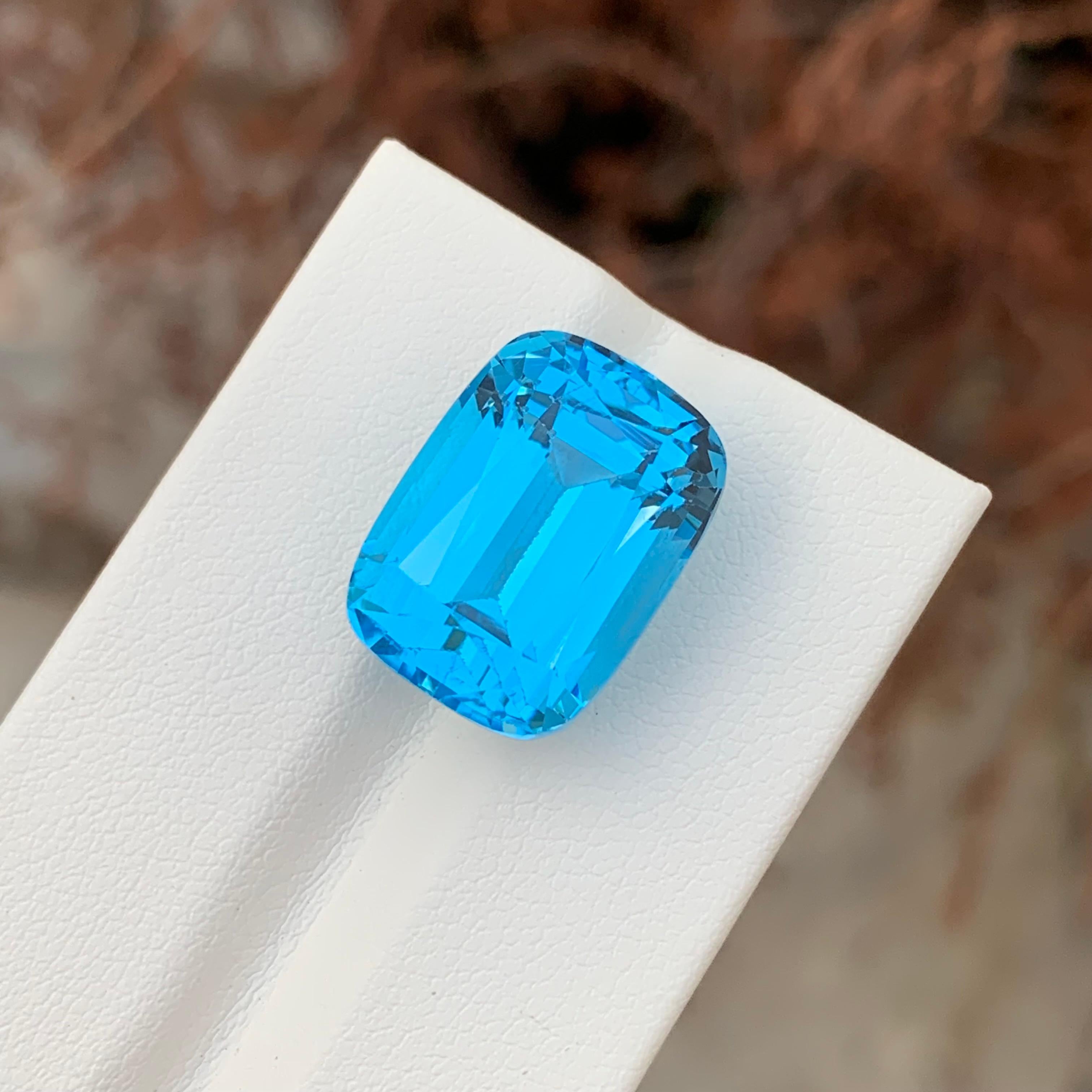 Women's or Men's 24.80 Carat Gorgeous Faceted Electric Blue Topaz Cushion Shape Gemstone For Sale