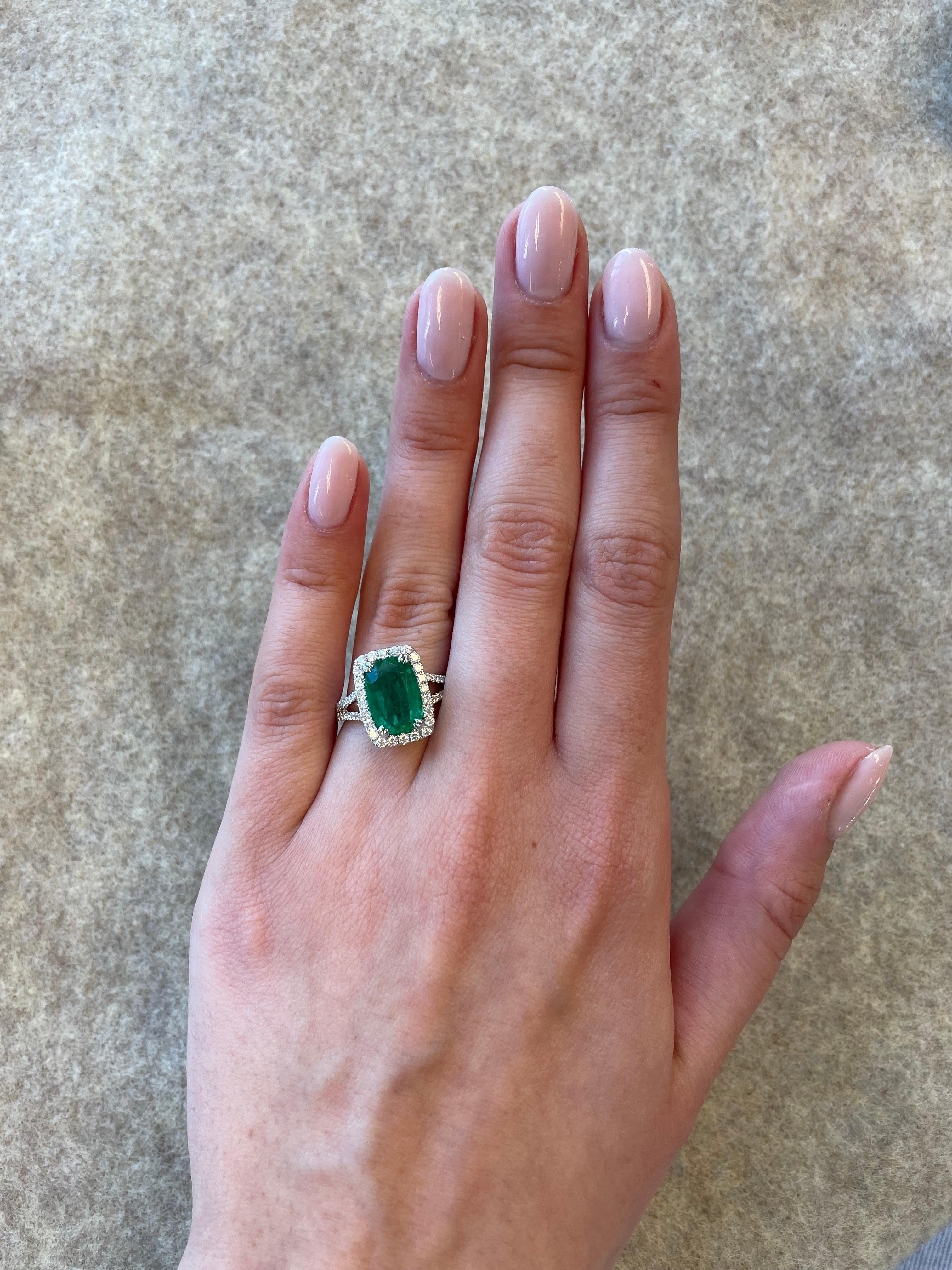 Stunning emerald and diamond halo ring with split shank.
3.16 carats total gemstone weight.
2.48 carat mixed cut emerald (hybrid cut between an oval cut and cushion cut). Complimented by 80 round brilliant diamonds, 0.68 carats. Approximately G/H