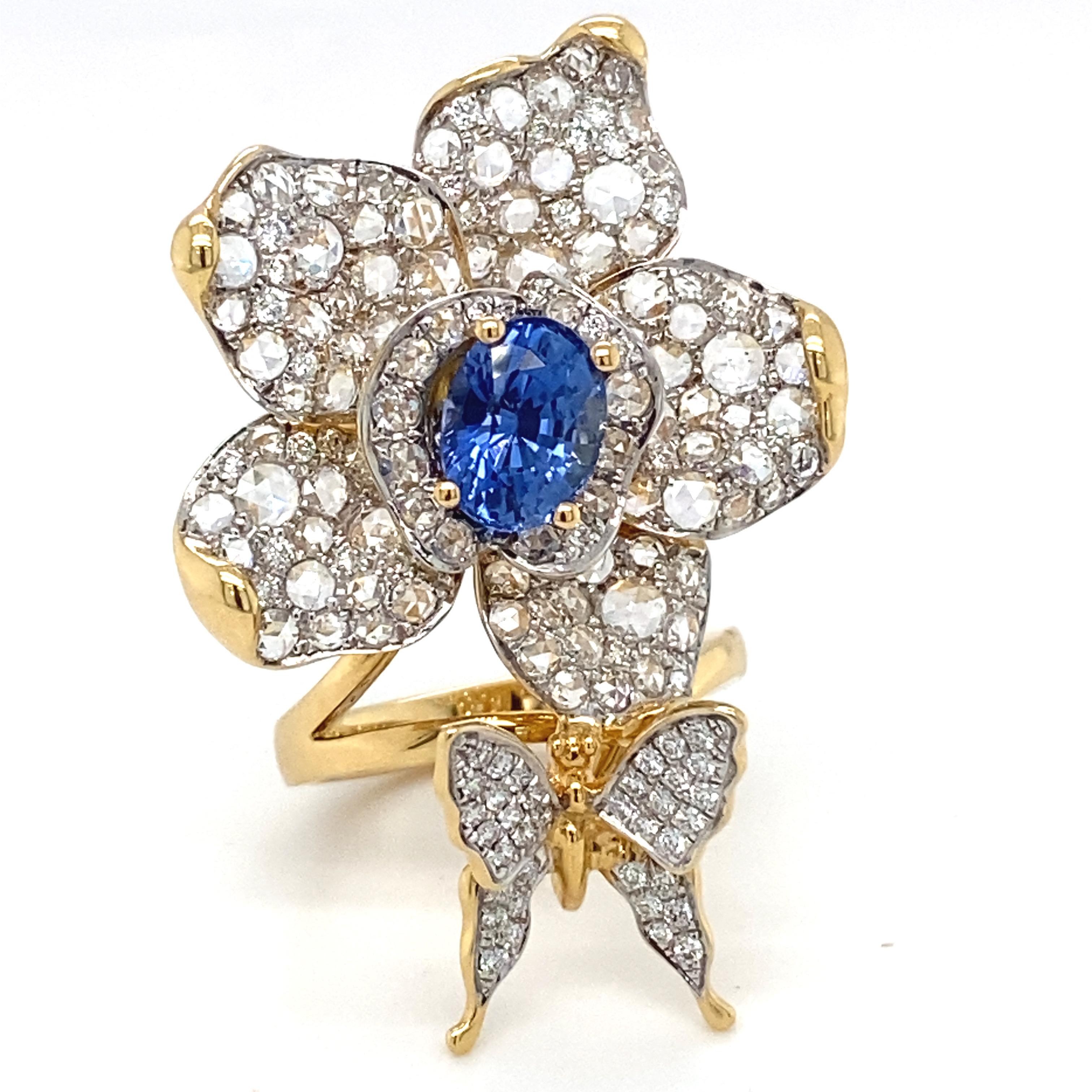 This magnificent floral ring boasts a delightful combination of blue sapphire and diamond. Flower petals and the butterfly is adorned with pave setting of white diamonds. Every detail work is carefully crafted and refined to create this exceptional
