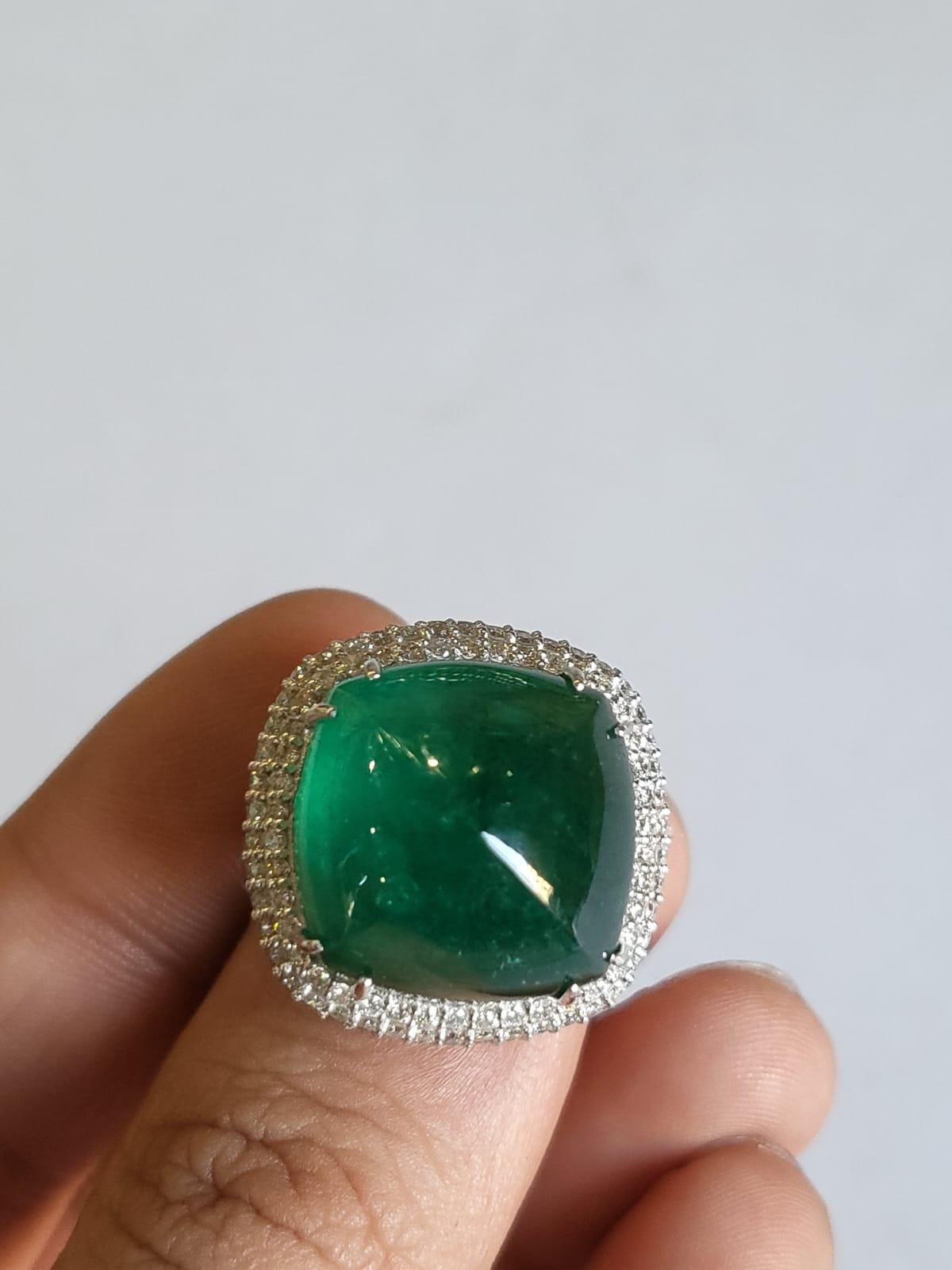 A very gorgeous and one of a kind, Emerald Engagement Ring set in 18K White Gold & Diamonds. The weight of the Emerald sugarloaf is 24.99 carats. The Emerald is completely natural, without any treatment & is of Zambian origin. The Diamonds weight is