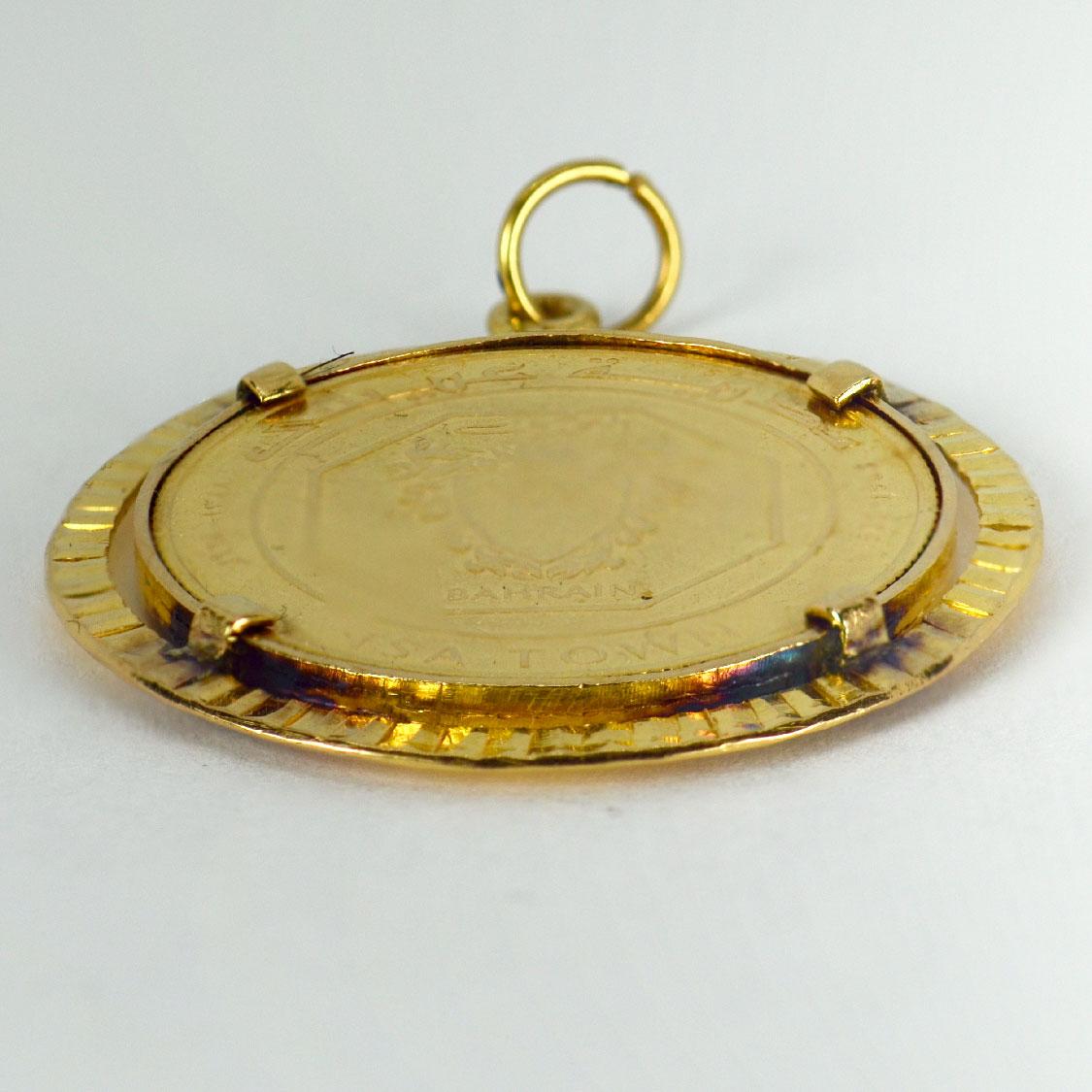 A yellow gold charm pendant designed as an 18 karat (18K)  coin holder containing a 24 karat (24K) Bahrain 10 Dinars gold coin. This rare coin was produced by the British Royal Mint in 1968 on behalf of the Middle Eastern country to mark the