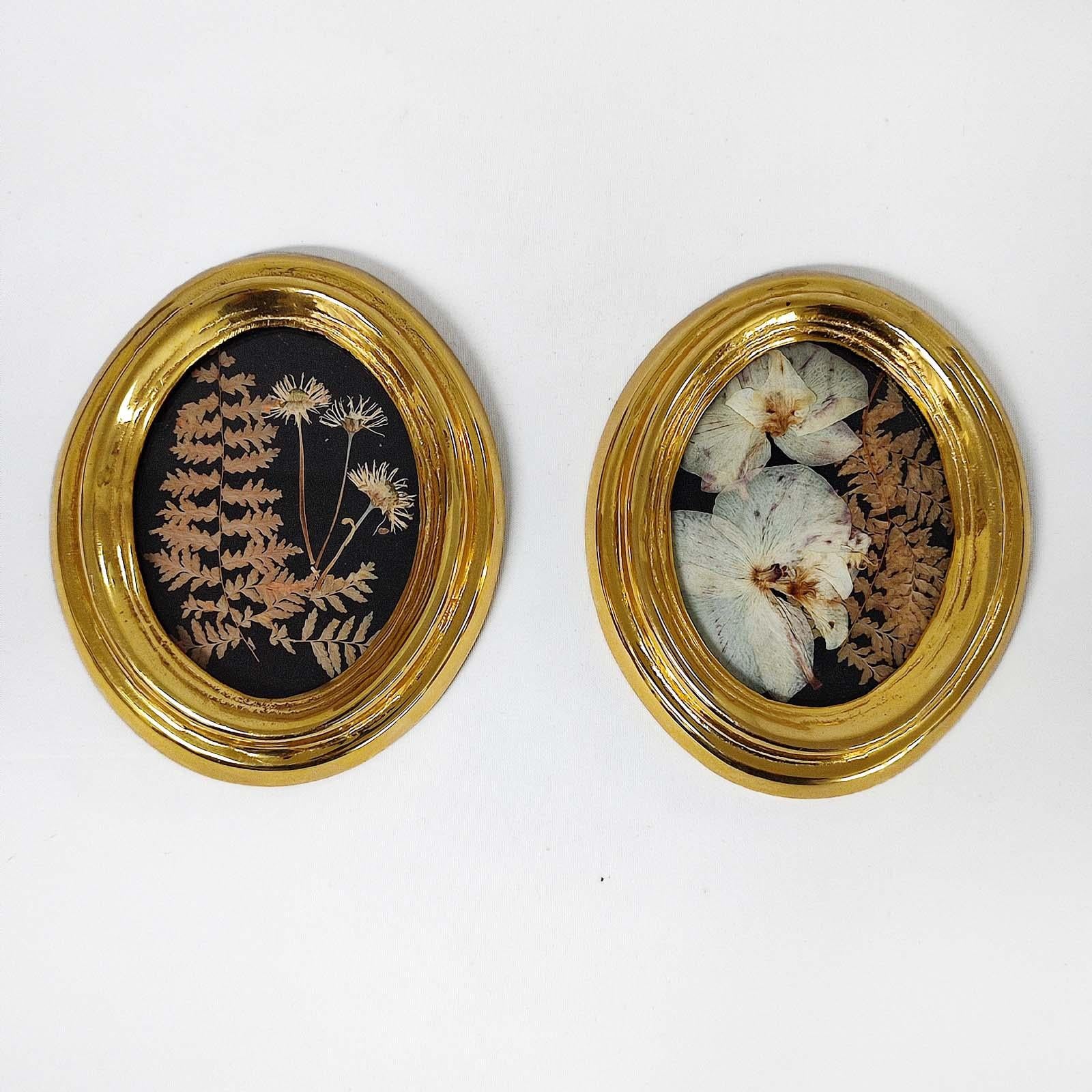 Pair of vintage oval brass frames, inner decor of with real pressed flowers, on a black velvet background. Solid cast brass, 24 K gold plated. With hangers on the backside for wall mounting. Each with original label.
In good overall condition, the