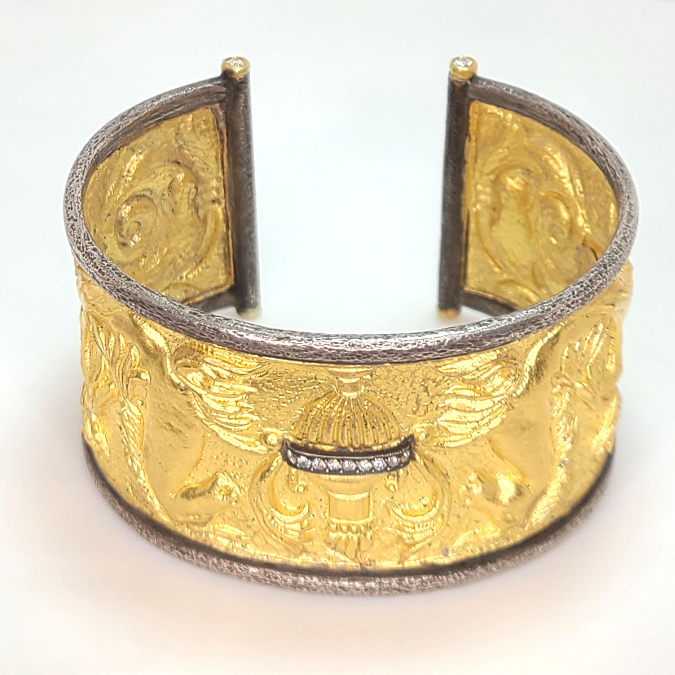 This 24k gold cuff bracelet relates back to ancient Greek times. The urn on the front of the bracelet is encrusted with round diamonds and there are additional 4 round brilliant diamonds one on each corner at the ends of the bracelet. It is