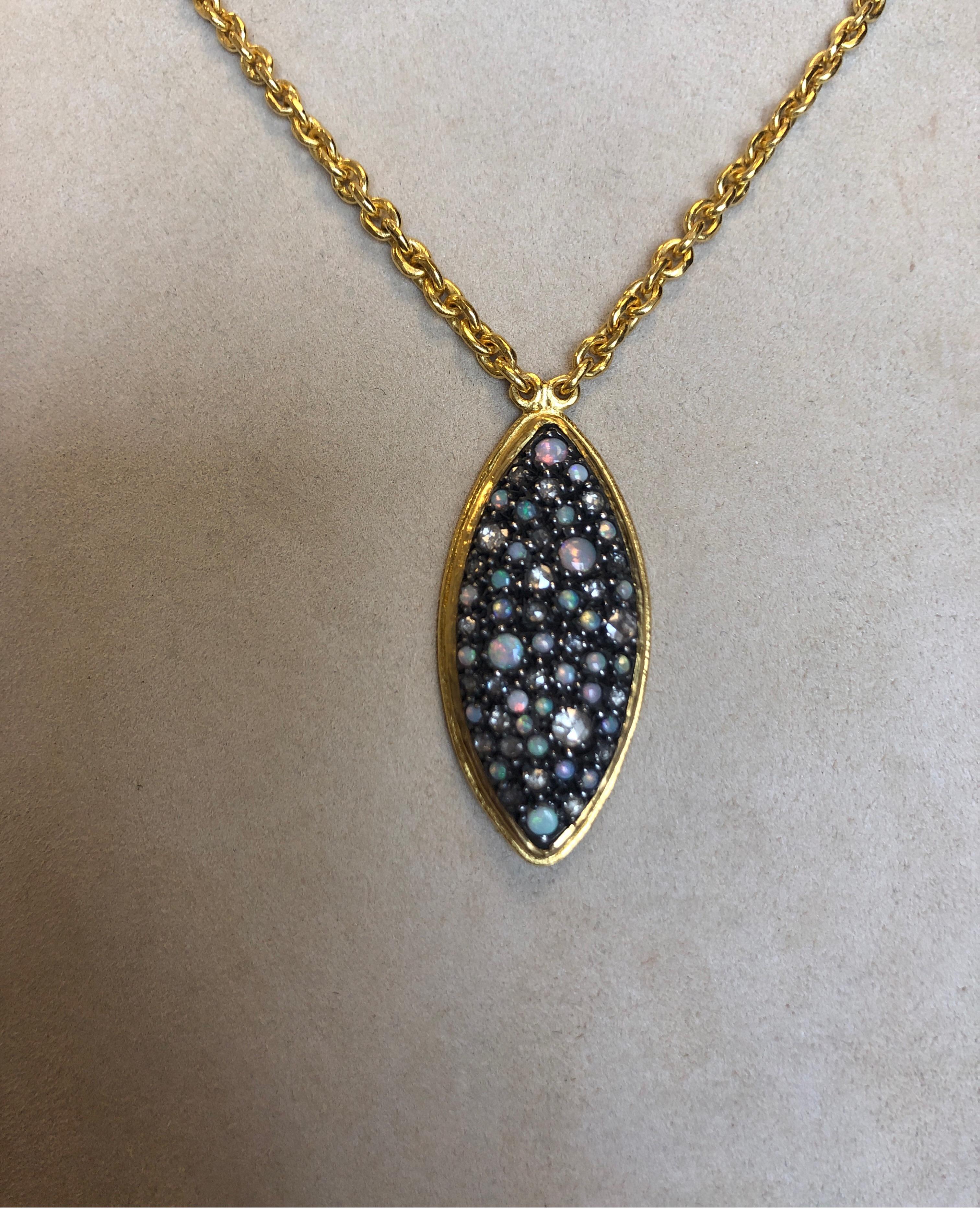 24K yellow gold pendant, prong set with round opals weighing 1ct total and round diamonds weighing 1ct total in a marquise shape in a gold bezel suspended from a 24K yellow gold 18 inch oval link chain, with lobster clasp.
Last retail $7500