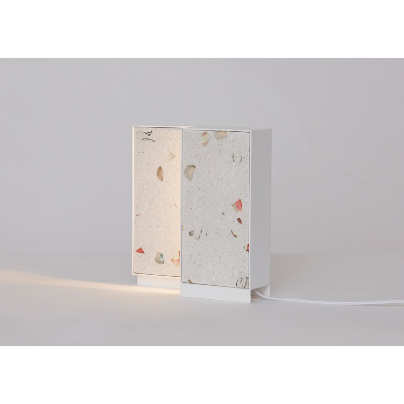 25/25 Table lamp by Llot Llov
Dimensions: W 25.5 x D 70 x H 27.3 cm
Materials: nail polish terrazzo.


The squared light 25/25 showcases the GLACIER. The material is framed in powder-coated steel. The light shines on the surface and brings out the