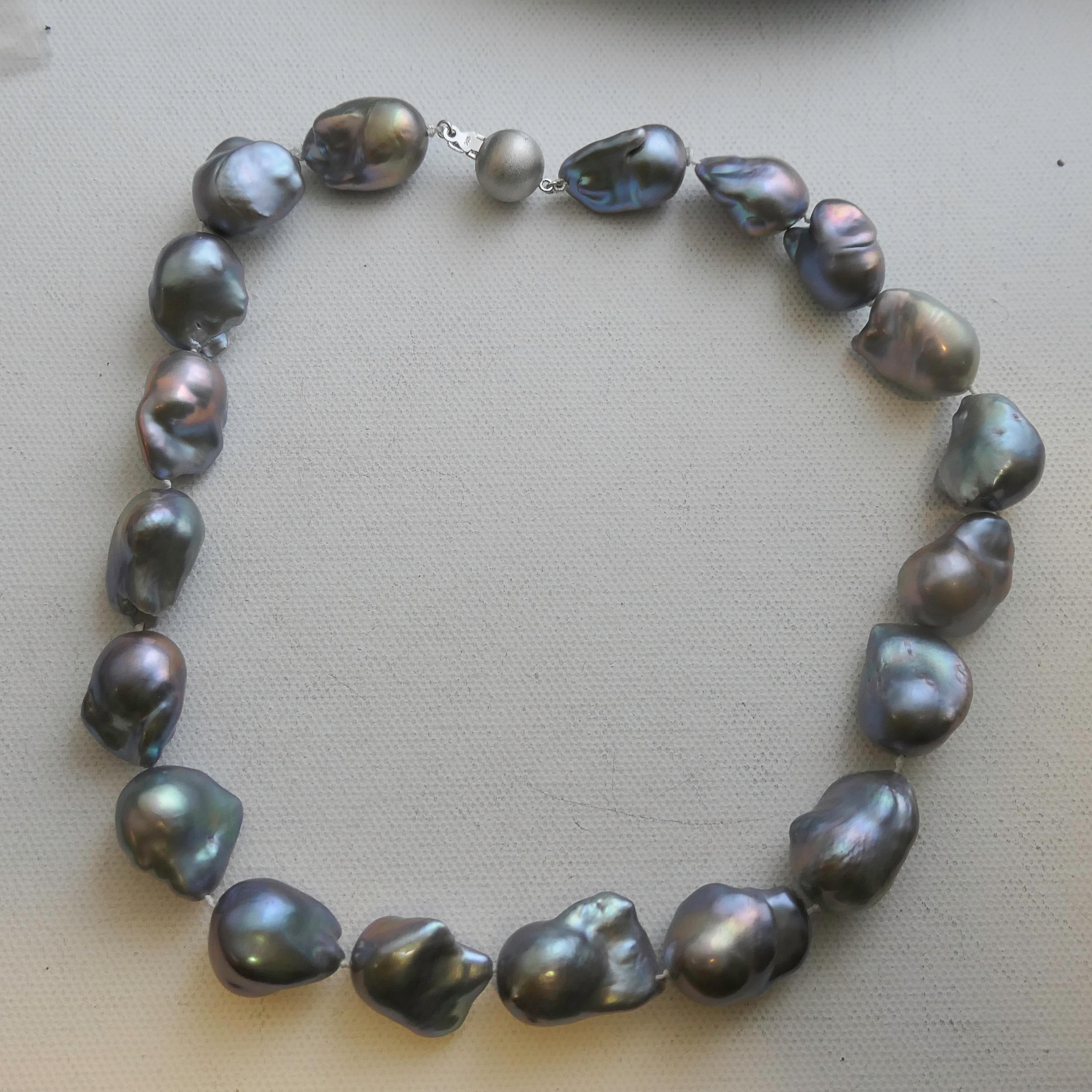 An exceptional necklace featuring 25–30 mm freshwater cultured baroque pearls in soft shades of silvery grey with overtones of peacock, lavender, and blue. Each pearl is individually hand-knotted on fine silk thread, showcasing its unique organic
