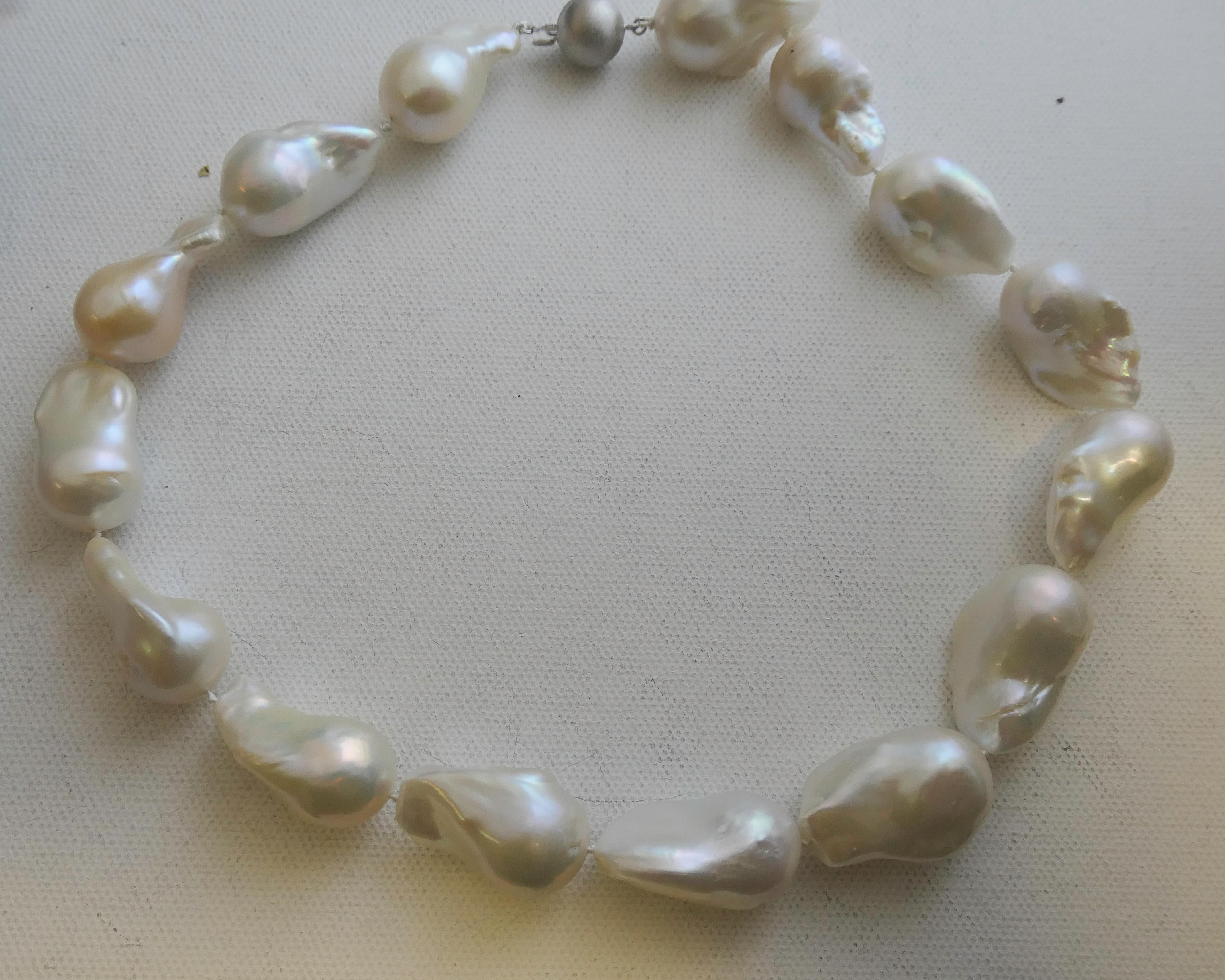 A striking necklace featuring 25–30mm freshwater cultured baroque pearls, each displaying the organic beauty and luminous glow unique to naturally formed pearls. The pearls are individually hand-knotted on fine silk thread, emphasizing their