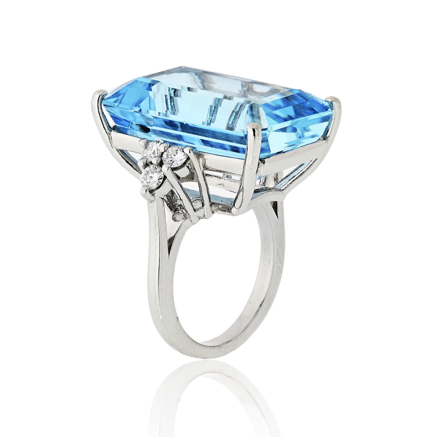 A stunning aquamarine and diamond ring crafted in platinum. Mounted with a 25 carat aquamarine of a medium-light blue color, with three diamonds accenting each side. 
Center stone measures: 23mm long and 15mm wide.
Finger size: 6.5.