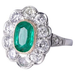 Anello di fidanzamento in platino con smeraldo colombiano e diamante aureolato da 2,5 carati