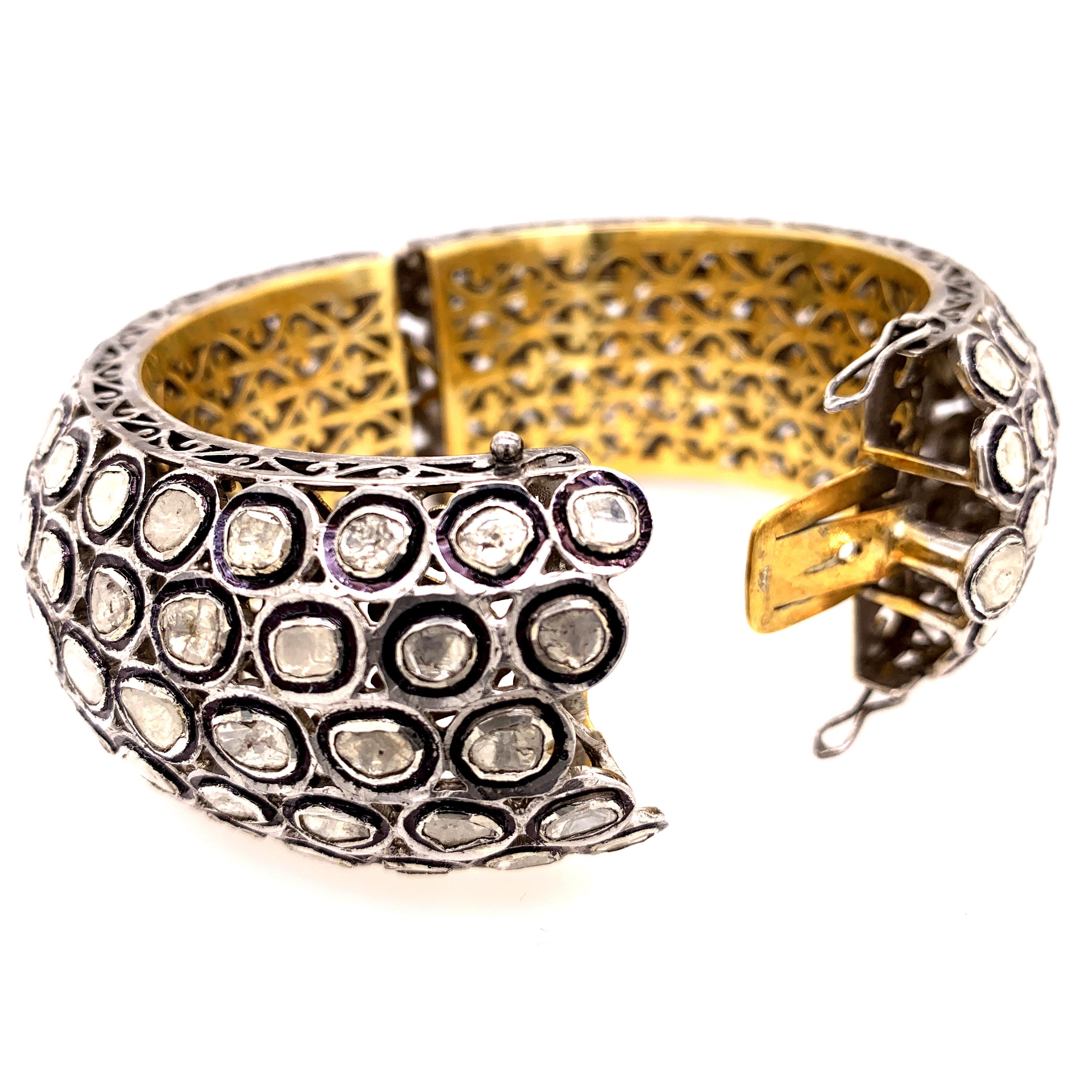 Maharaja inspired diamond bangle. Handcrafted fancy cut and tabular cut diamonds mounted in bezel setting, accented with black enamel around the diamonds. Contemporary, oxidized silver with 18 karat gold plated basket cut design inside of bangle,