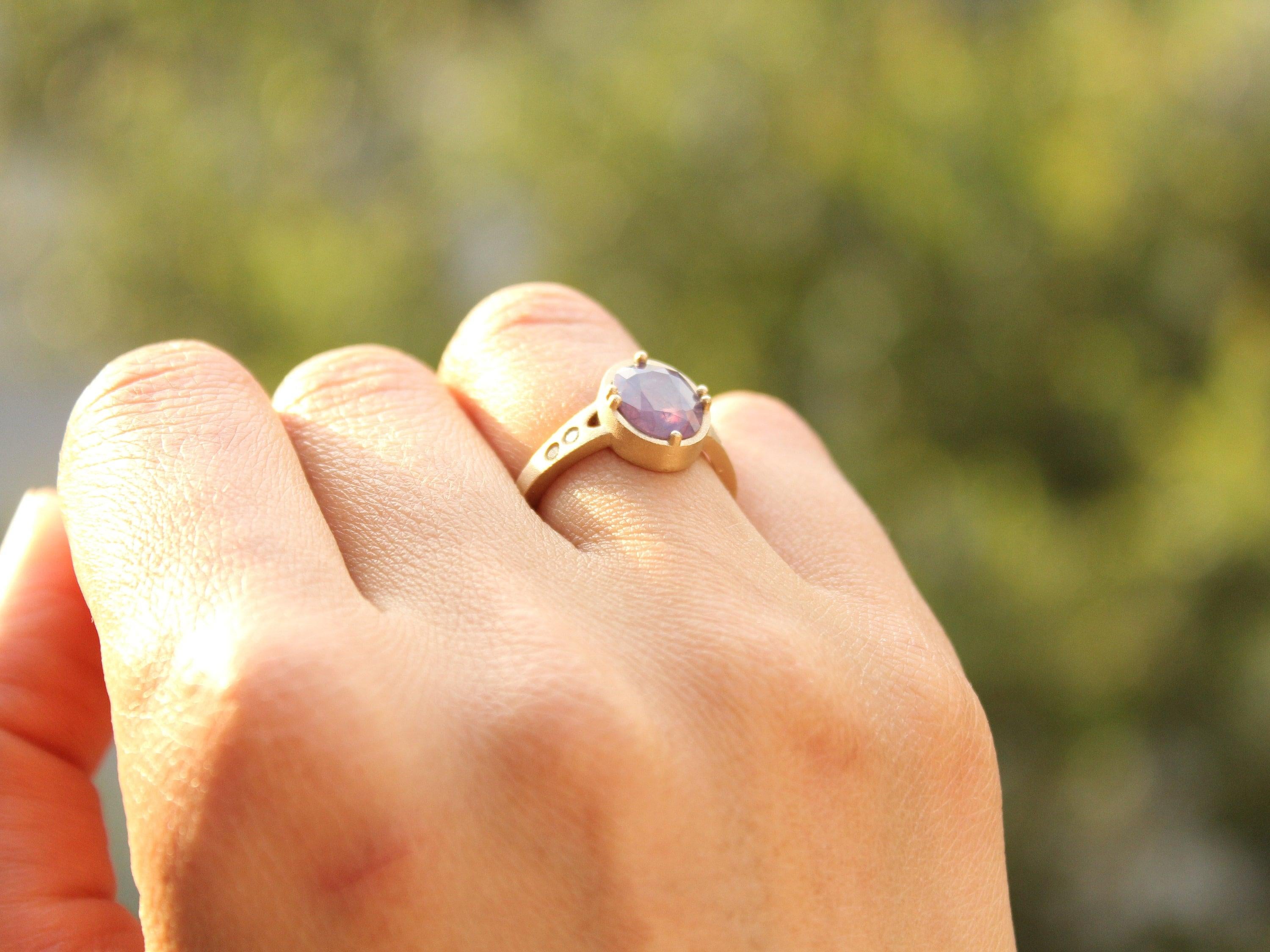 This one-of-a-kind purple sapphire and diamond ring is a striking piece, set in a prong and bezel setting with brushed 14k yellow gold. Its unique design makes it a perfect choice for an alternative engagement ring or a standout right-hand fashion