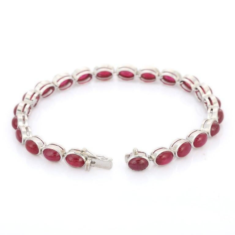 Elevate your jewelry collection with this striking 18K white gold bracelet, featuring a captivating series of vivid ruby cabochons totaling 25.00 carats. Each oval-cut ruby is bezel-set to highlight its rich crimson hue and smooth, polished finish,