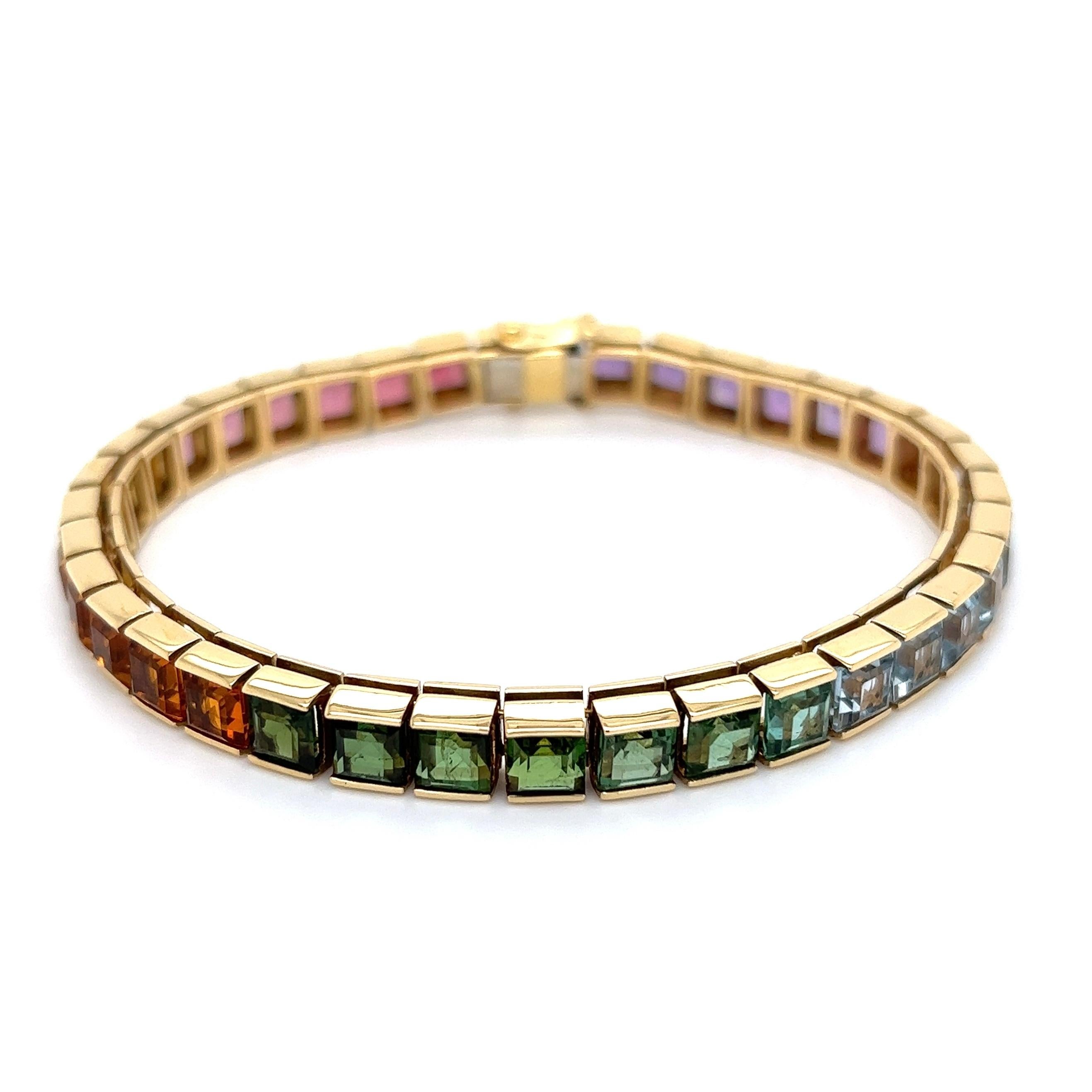 Simply Beautiful! Rainbow Multi Gemstone Line Gold Tennis Bracelet. Featuring 36 Pink Tourmaline, Citrine, Green Tourmaline, Blue Topaz and Amethyst, weighing approx. 25.00tcw. Measuring approx. 8” l x 0.25” w x 0.19” h. Hand-crafted in 18K Yellow