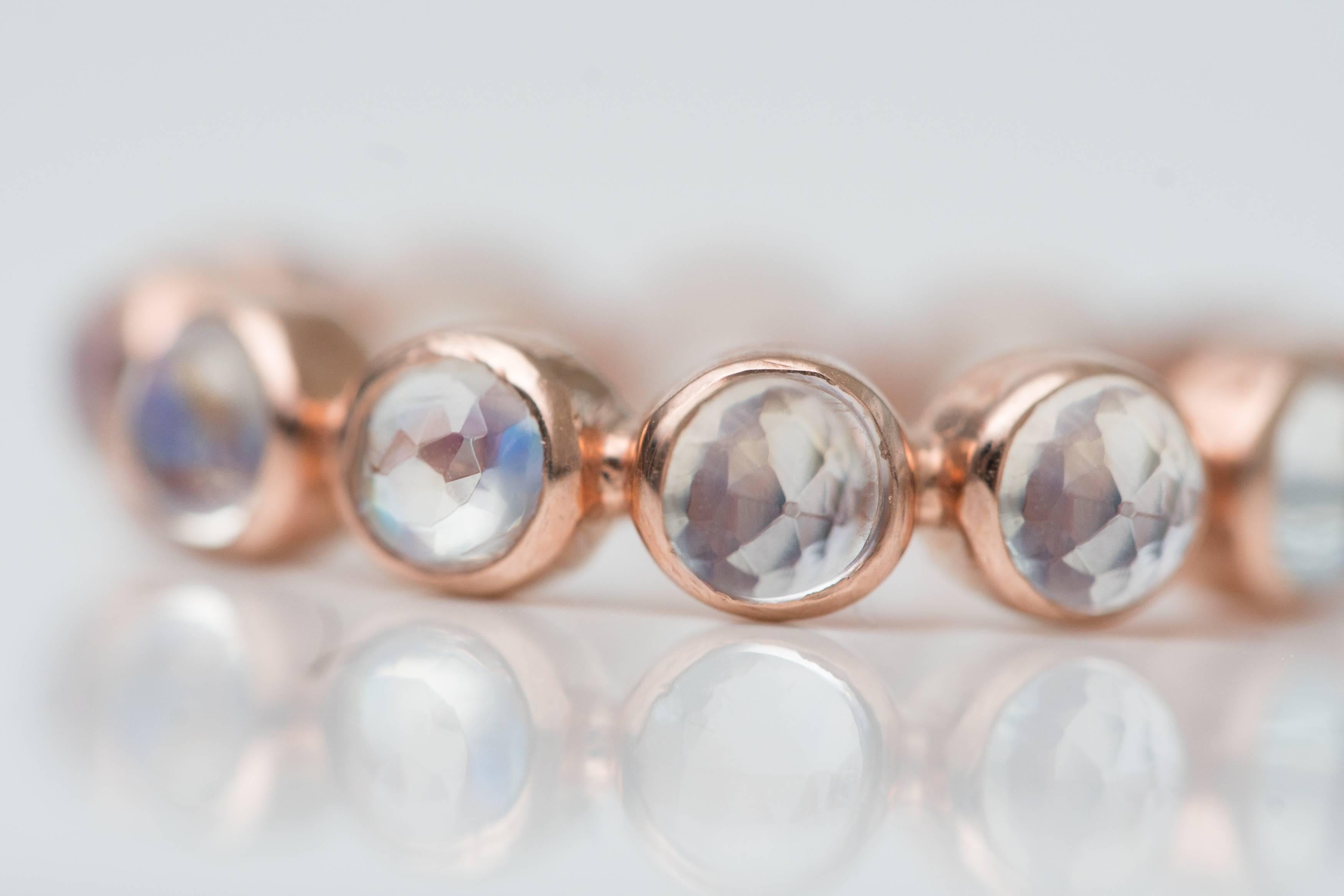 2.5 Carat Rainbow Moonstone and 18 Karat Rose Gold Eternity Band

Features a ring of Rainbow Moonstones in 18 Karat Rose Gold. The Round Brilliant gemstones are bezel set in 18 Karat Rose Gold. The sides of the ring have a smooth, high polish