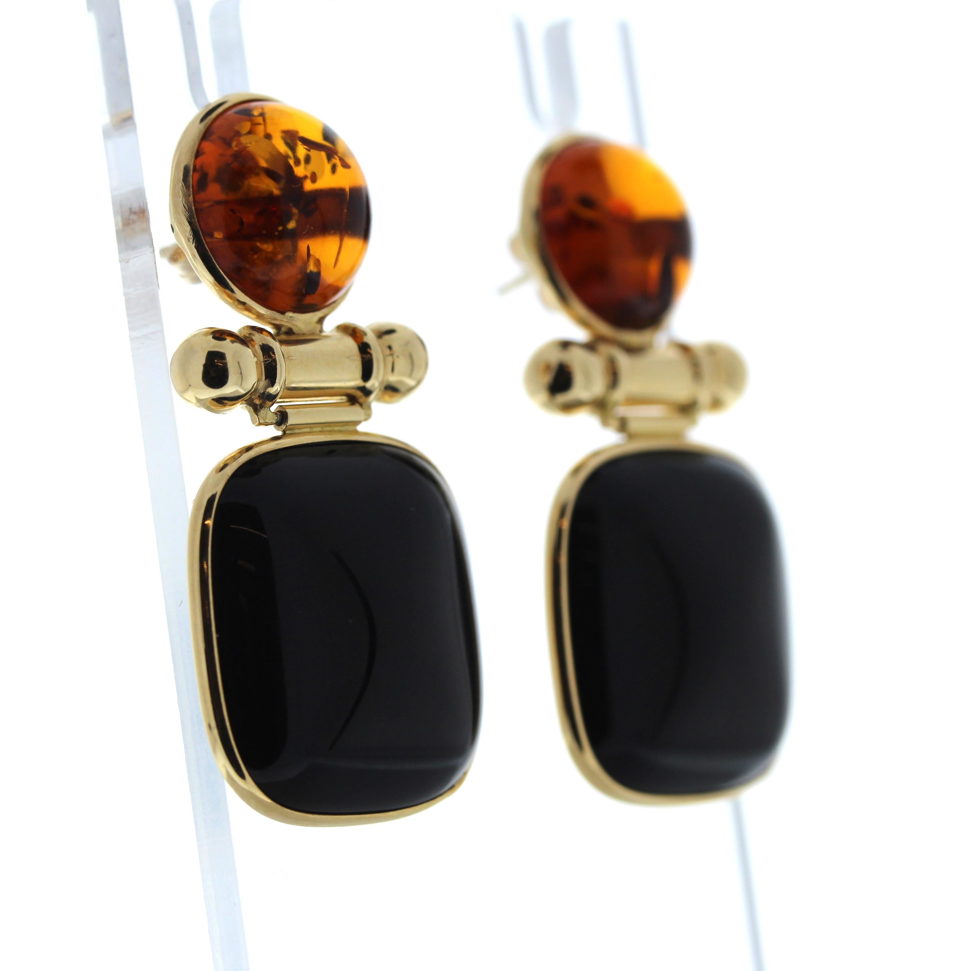 A pair of earrings that each center a round onyx, each measuring approximately 21mm and a round cabochon citrine, each measuring approximately 13mm. Fastened by posts and push backs. 14K Yellow Gold. Approximate Total Gross Weight: 14.08 Grams. 1