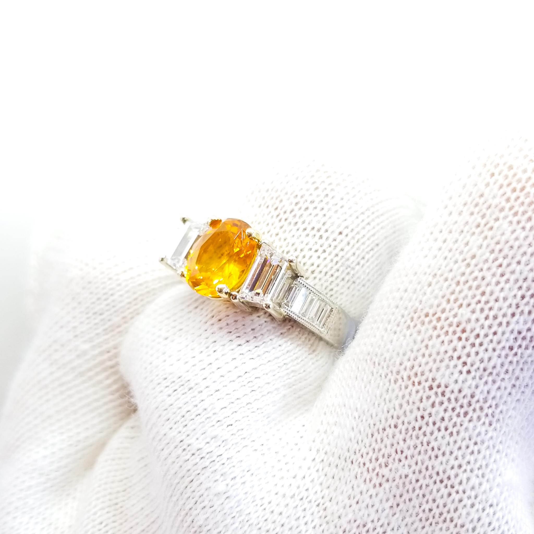 Este Anillo de Compromiso de Tres Piedras o de Aniversario, inspirado en el Art Decó, para la mano derecha, presenta un Zafiro Ovalado de Calidad Gema AAA de 2,50 Quilates de un intenso tono Amarillo Anaranjado / Calabaza Brillante. La Gema muestra