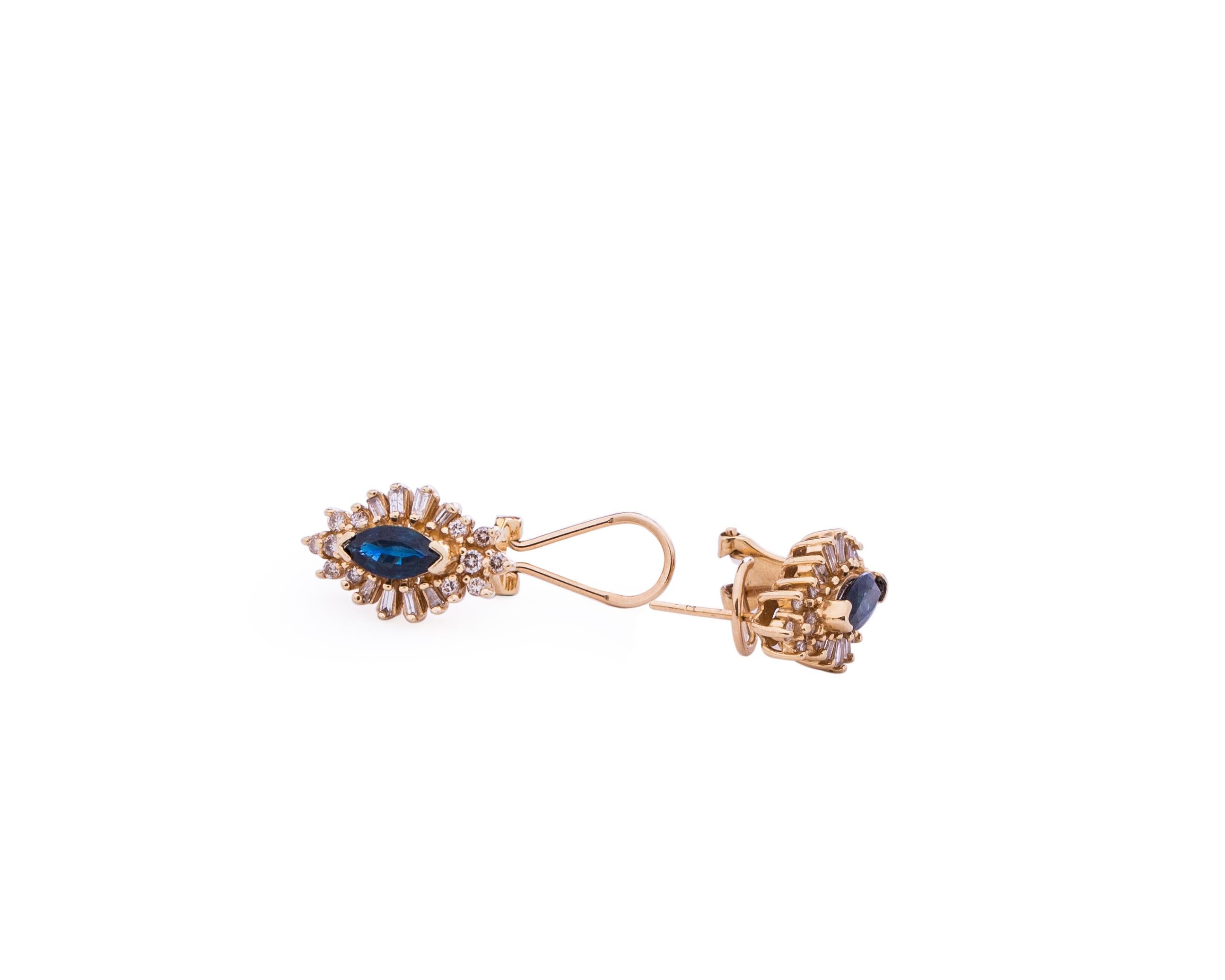 Stunning retro vintage earrings from the 1970s! These feature a beautiful royal blue marquise sapphire in the center, v-prong set. The sapphire is surrounded by an array of diamonds, round and baguette cut. These earrings are crafted in 14 karat